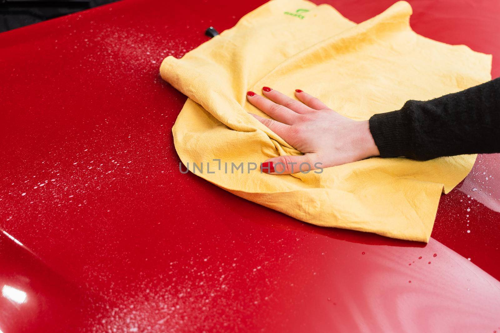 Car polishing with yellow microfiber cloth. Protection of paintwork.