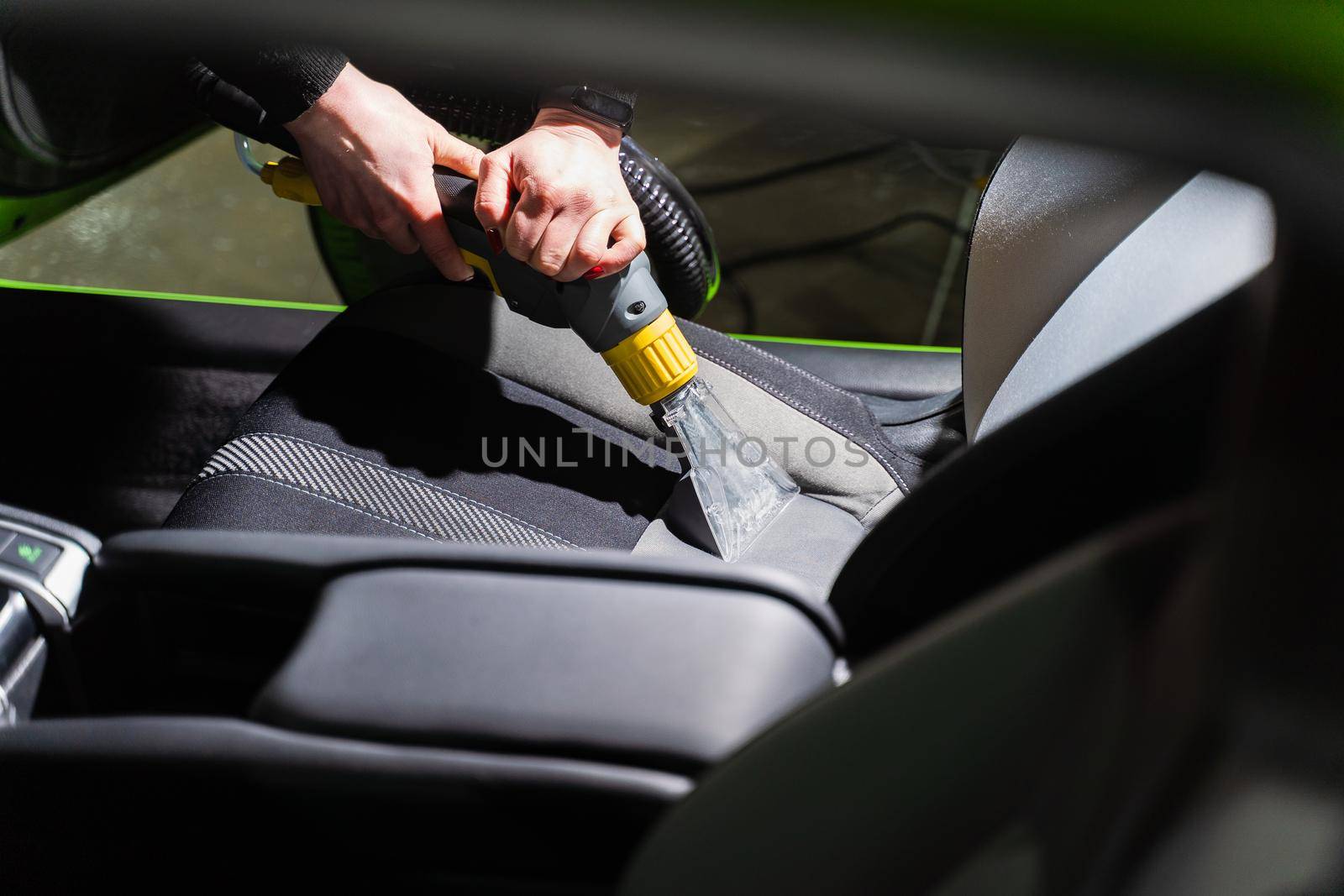 Cleaning car salon dry cleaning with vacuum cleaner. Professional use of a steam vacuum cleaner to remove stains