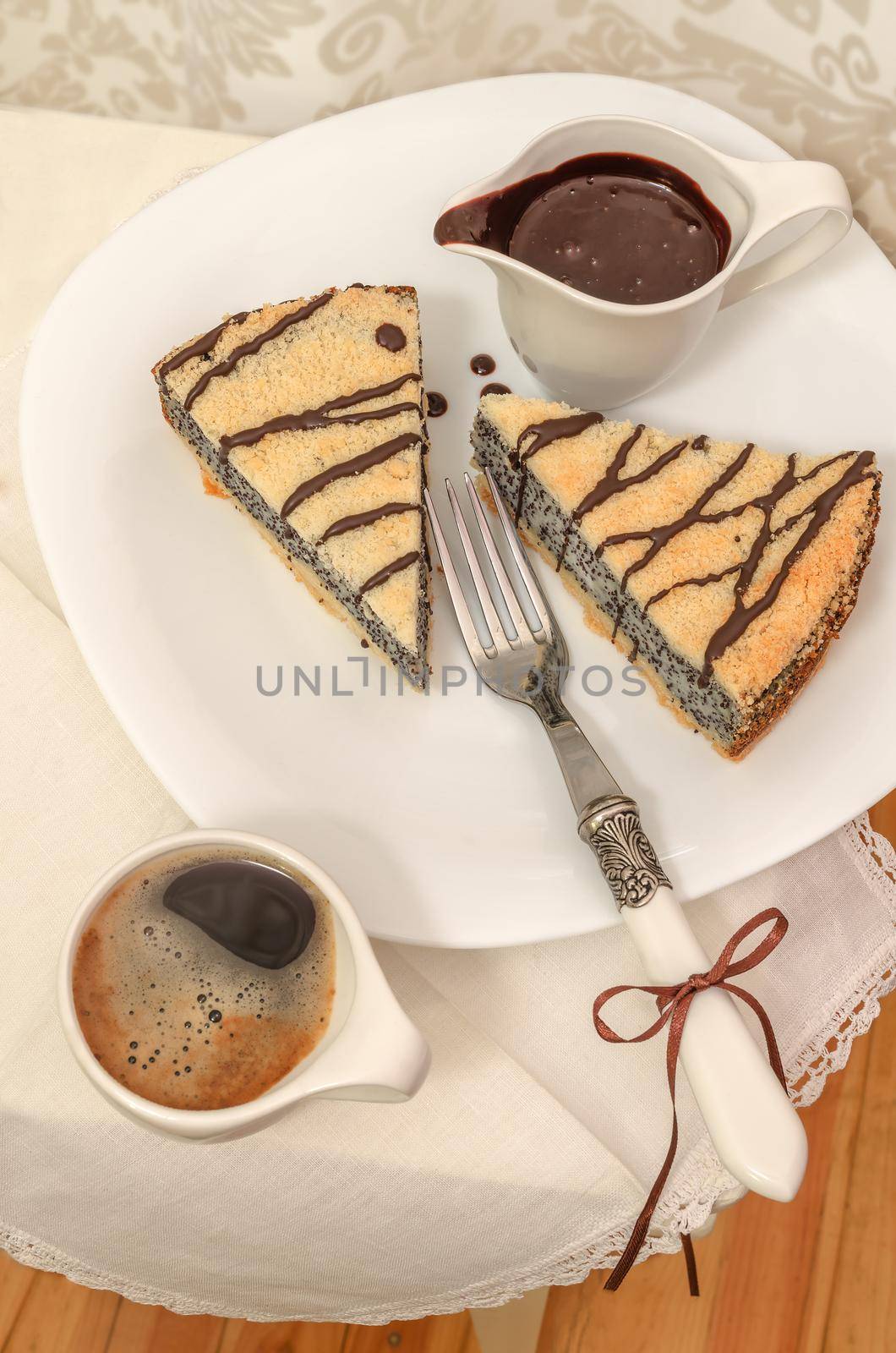 German poppy seed cake on white plate with chocolate and coffee