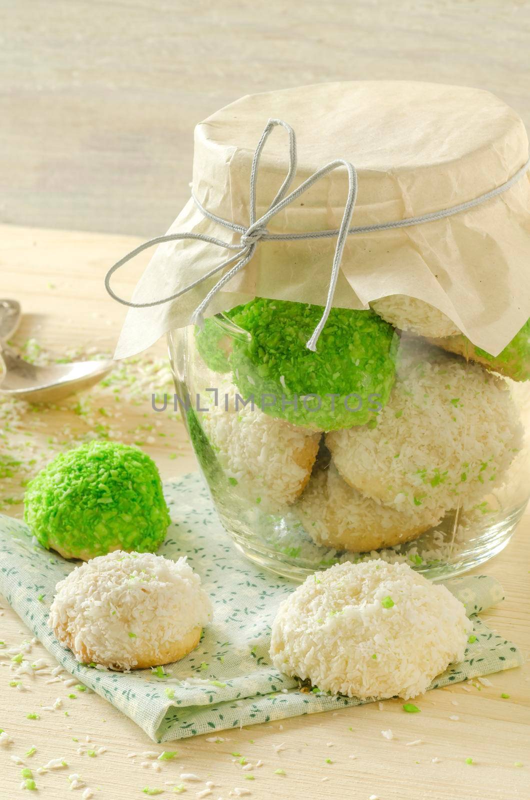 Sugar cookies with coconut flakes in glass jar. Near napkin. Selective focus
