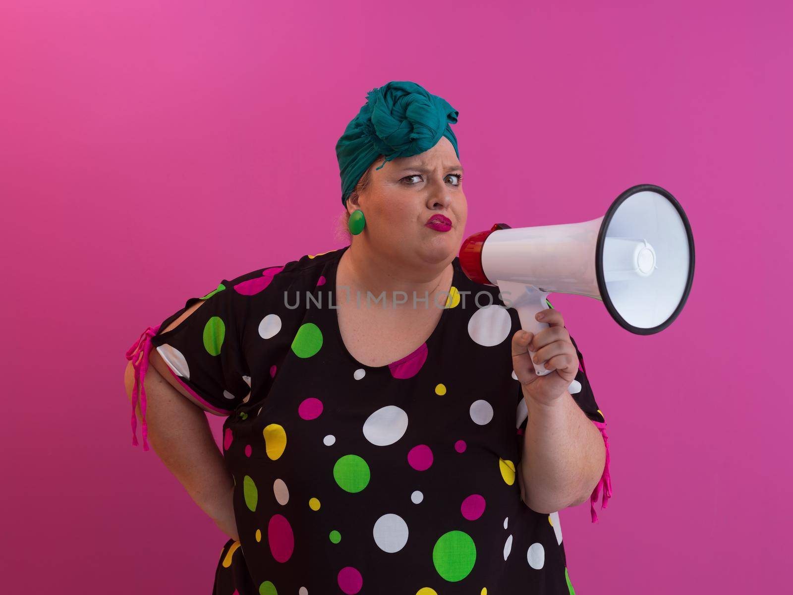 Funny plus size woman woman posing isolated on pink background studio portrait. People emotions lifestyle concept. Mock up copy space. Screaming in megaphone. High quality photo