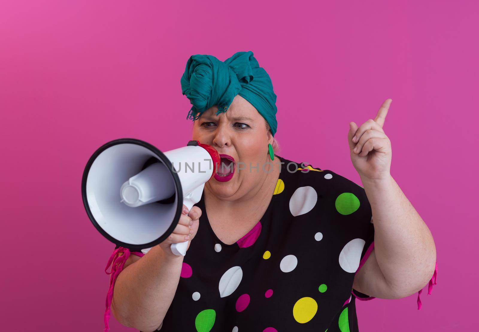 Funny plus size woman woman posing isolated on pink background studio portrait. People emotions lifestyle concept. Mock up copy space. Screaming in megaphone. High quality photo
