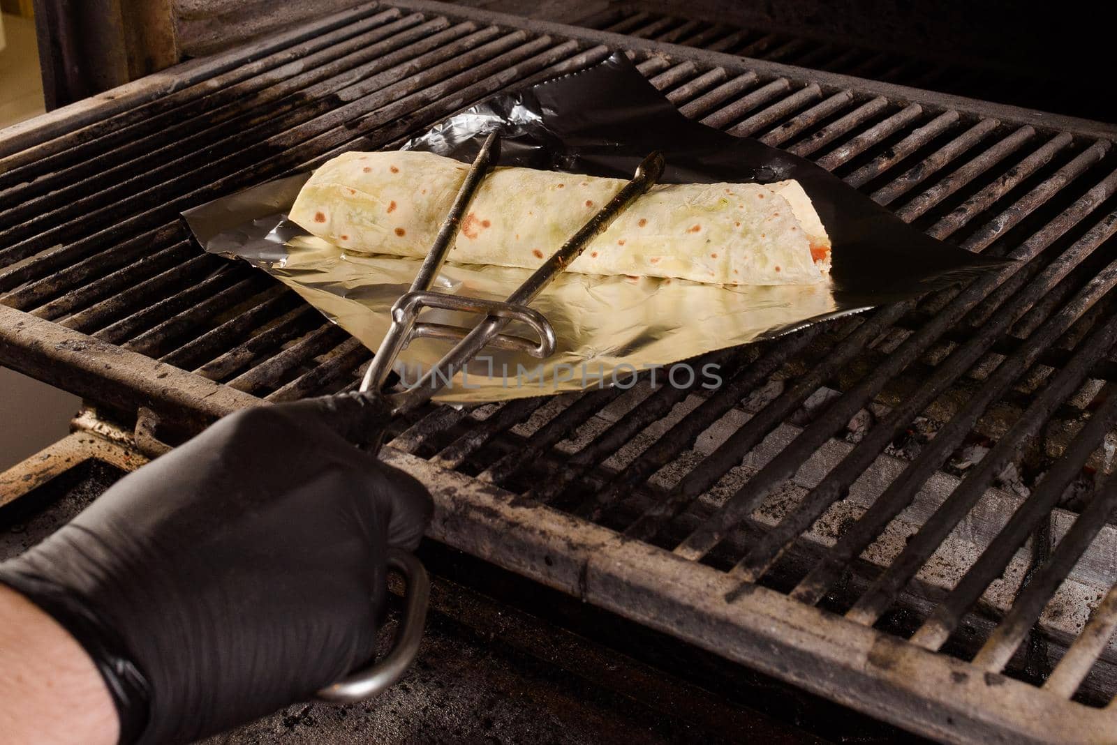 The process of making a foil grilled burrito. Mexican dish by Rabizo