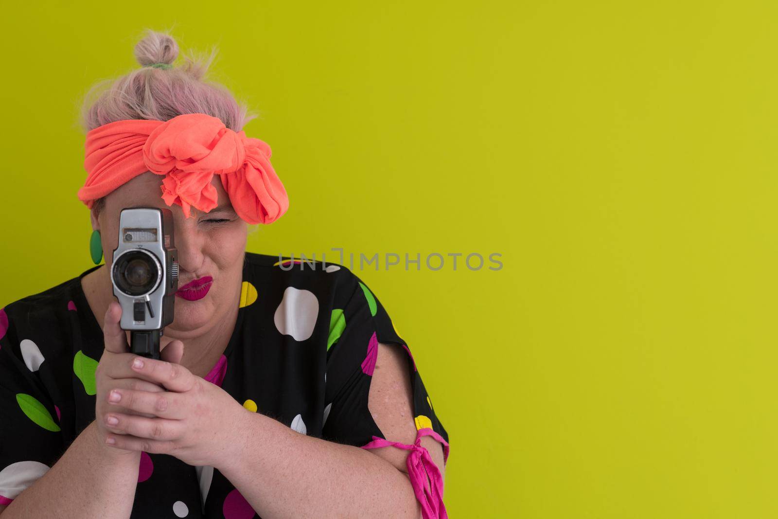 plus size smiling woman with funny emotional face expression with vintage camera in dress isolated on green background, traveler on vacation, summer fashion style, excited tourist. High quality photo