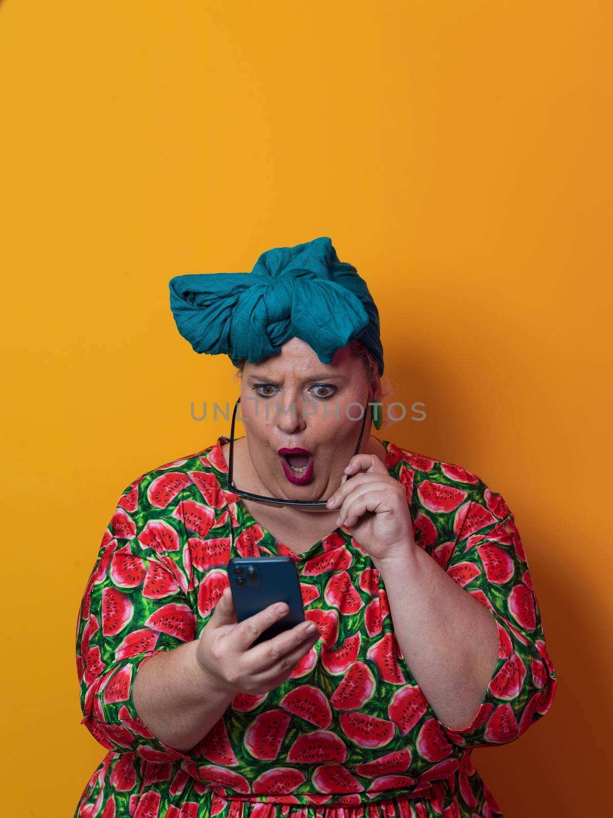 Blonde plus size woman having conversation talking by smartphone over yellow background smiling with an idea or question pointing finger with happy face, number one by dotshock