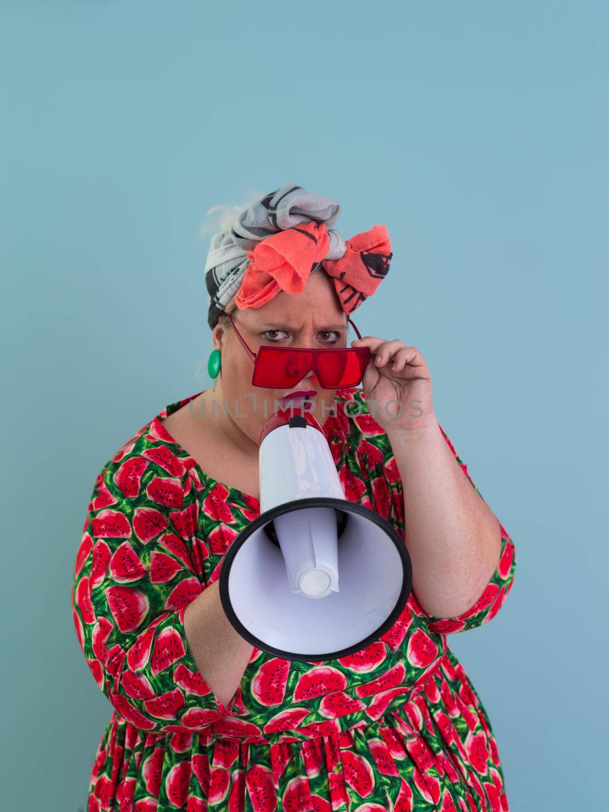 Funny plus size woman posing isolated on cyan background studio portrait. Screaming in a megaphone. People emotions lifestyle concept. Mock up copy space. by dotshock