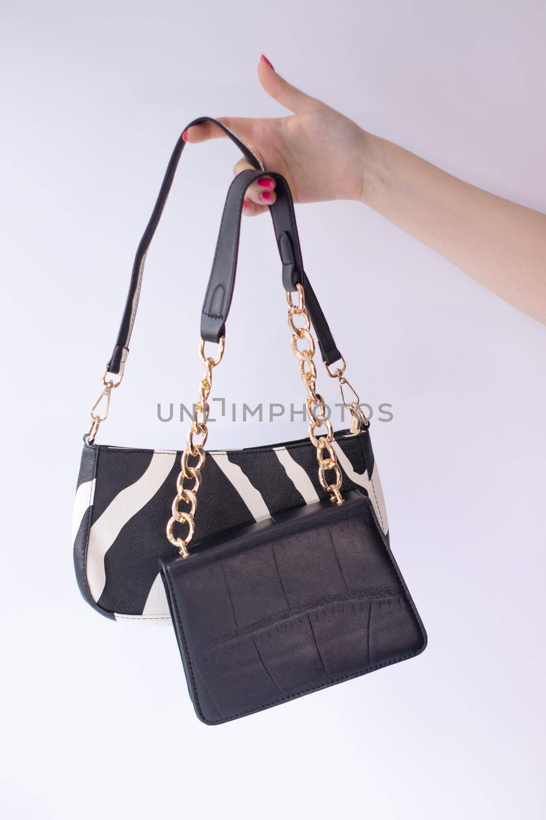 close up of womans hand holding fashionable little black bag. Product photography. stylish handbag and purse for women.