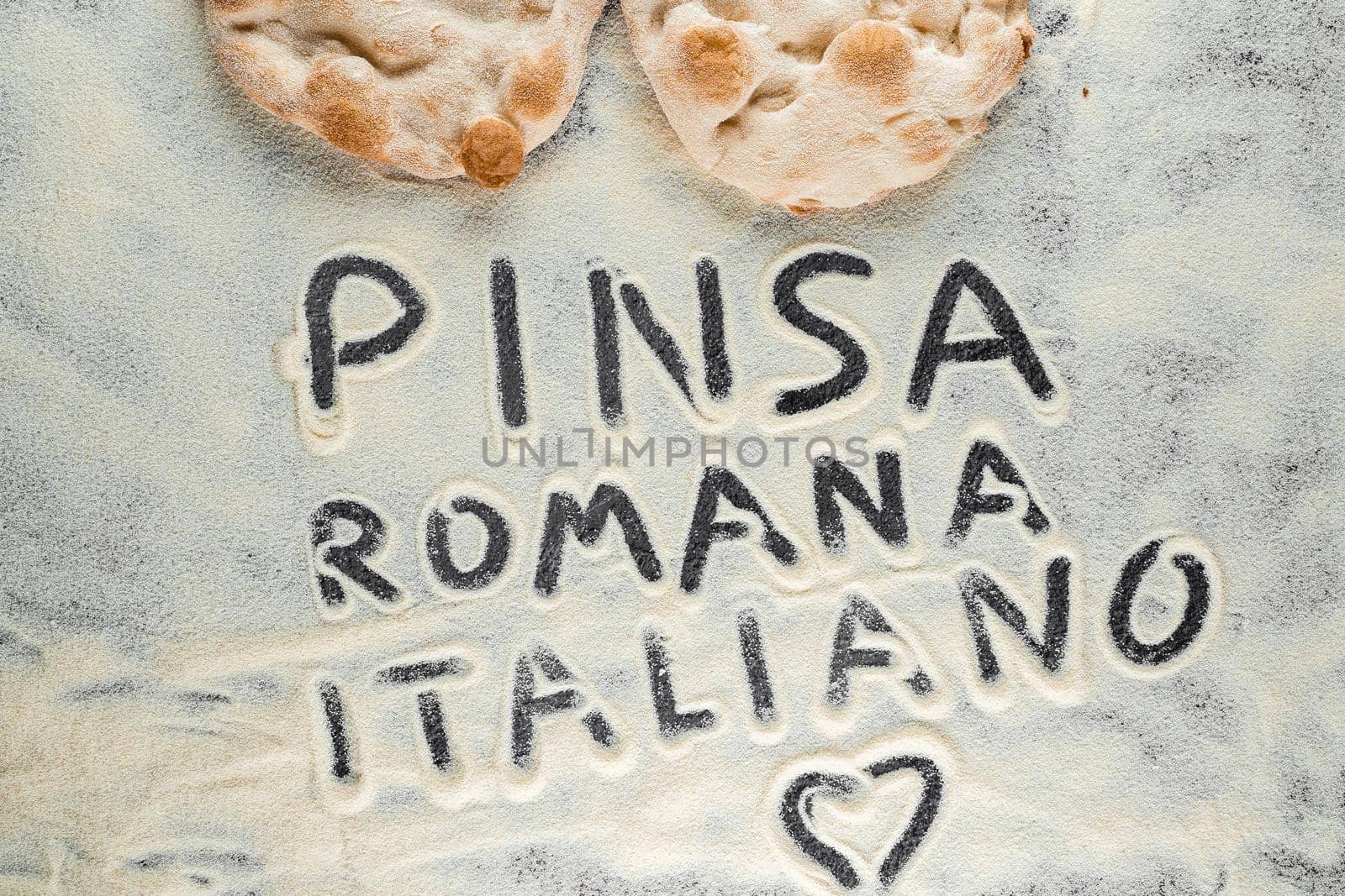 Dough and flour with text pinsa romana italiano on black background. Scrocchiarella gourmet italian cuisine. Traditional dish in italy