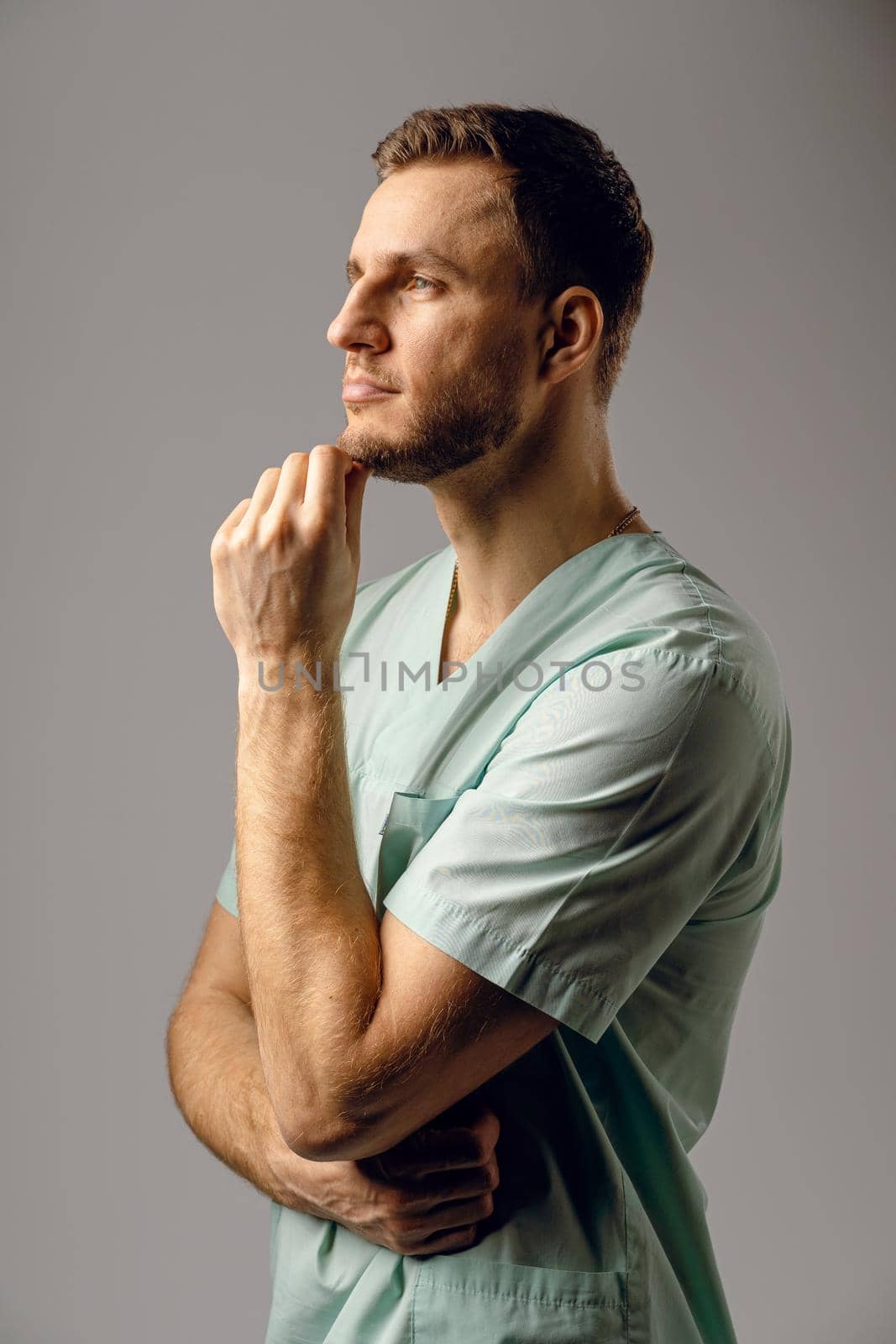 Surgeon weared in medical robe smile and posing on white background. Handsome happy doctor posing in studio