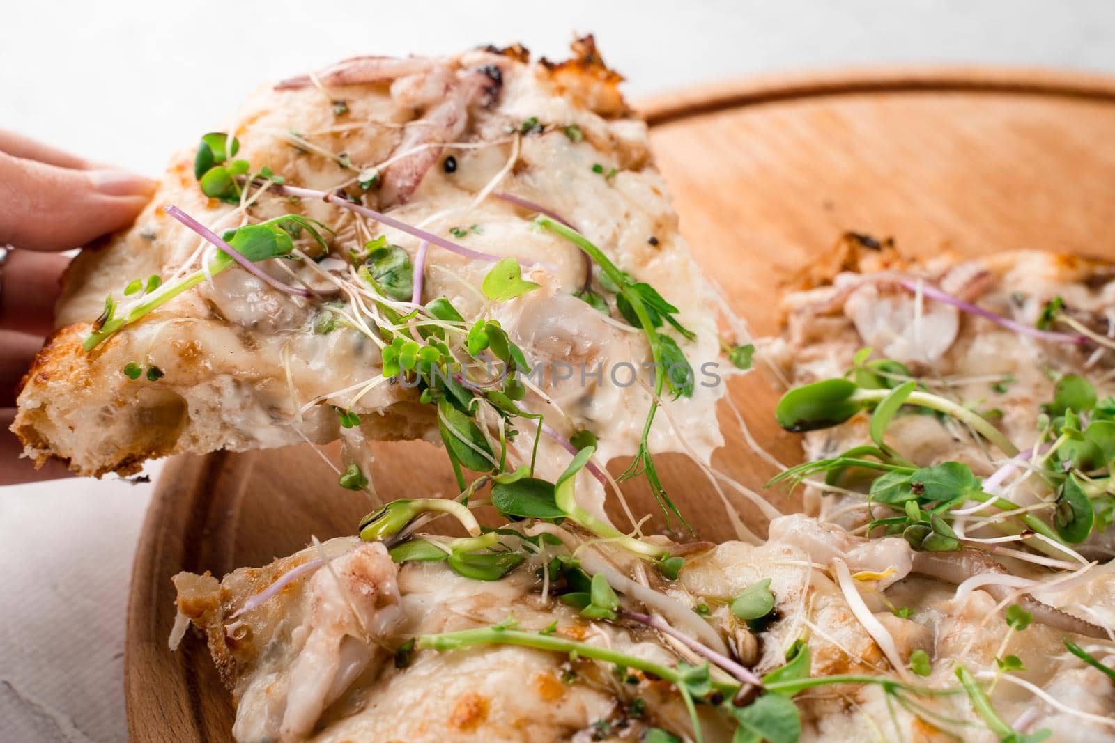 Pinsa romana with octopus seafood, cheese, microgreen. Italian gourmet cuisine. Scrocchiarella