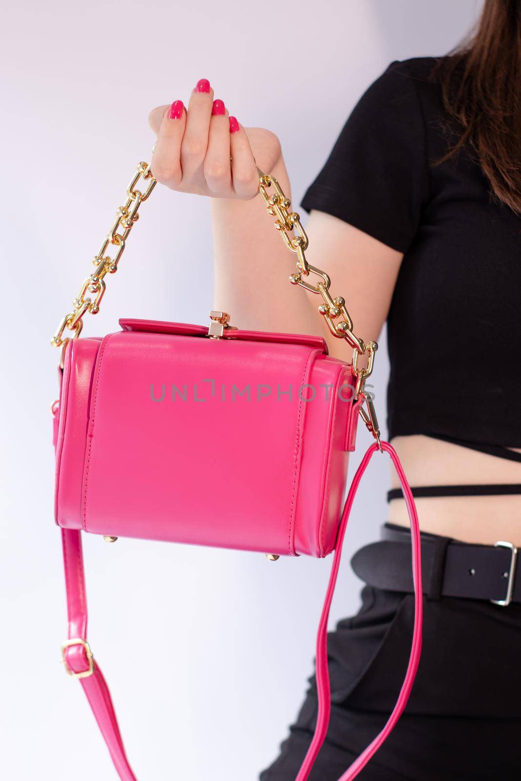 womans hand holding a pretty little pink handbag. Product photography. stylish handbag and purse for women. by oliavesna
