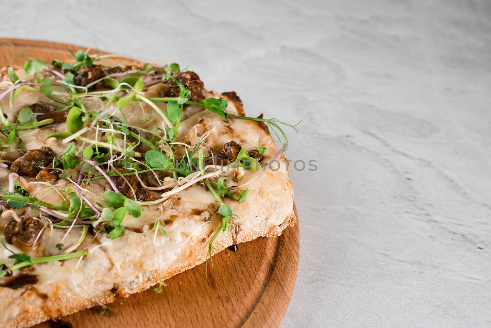 Italian pinsa romana with french escargot grape snails on white background. Pinsa with snail, cheese, microgreen. Italian gourmet cuisine.