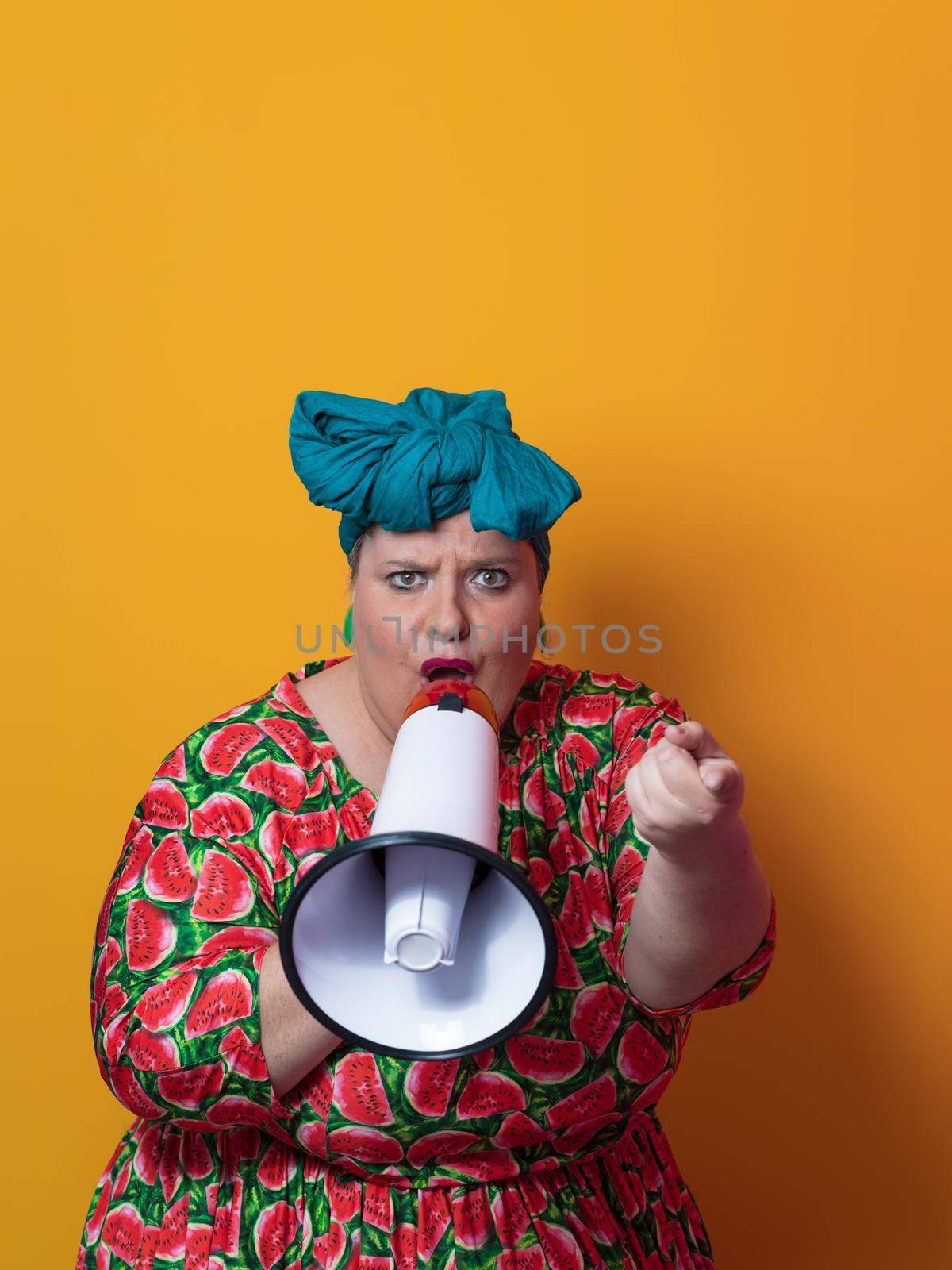 Funny plus size woman posing isolated on yellow background studio portrait. Overweight lady screaming in a megaphone. People emotions lifestyle concept. Mock up copy space. High quality photo