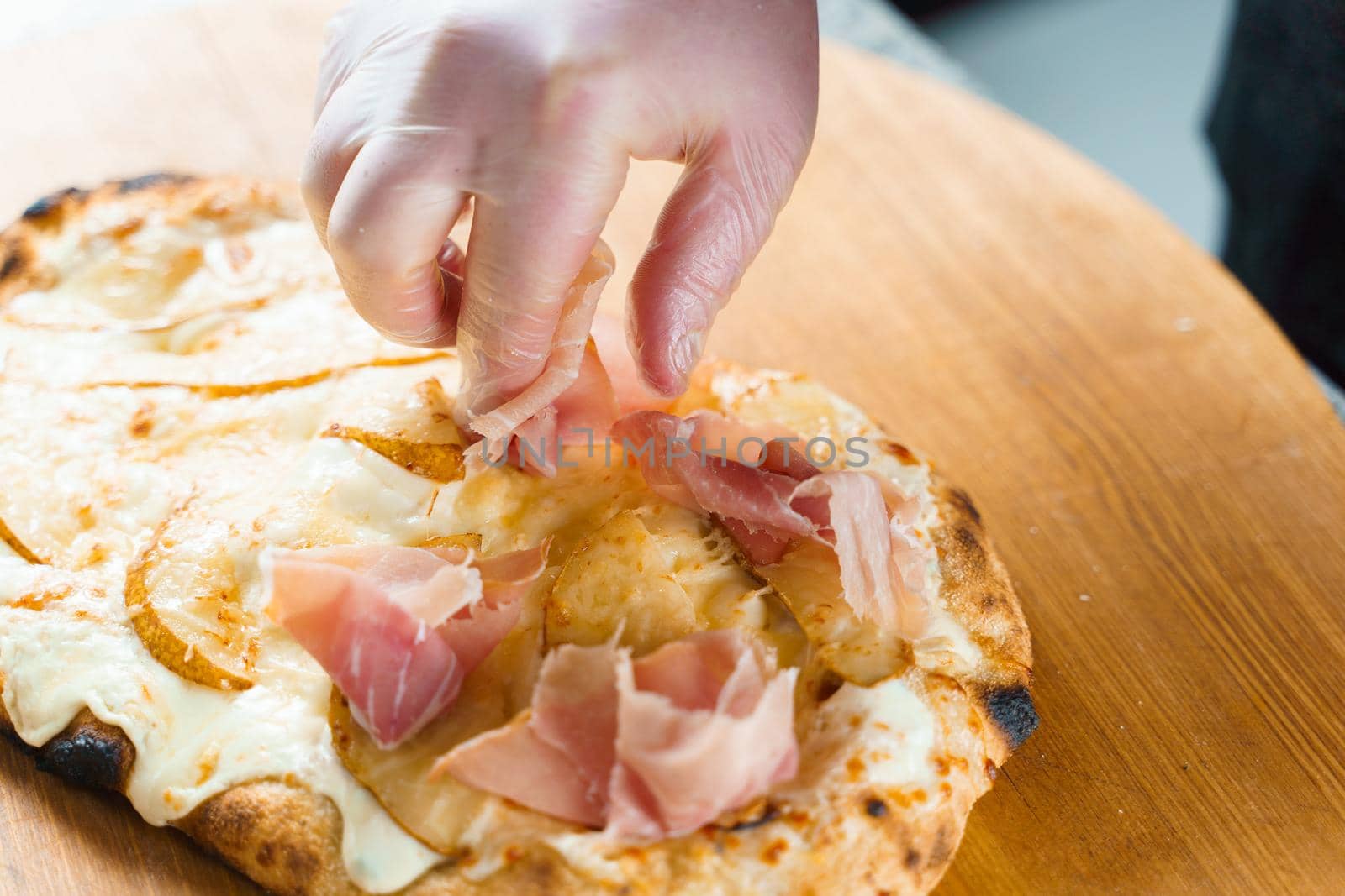 Chef cooking pinsa romana with pear, cheese, prosciutto in delivery box. Scrocchiarella gourmet italian cuisine. by Rabizo