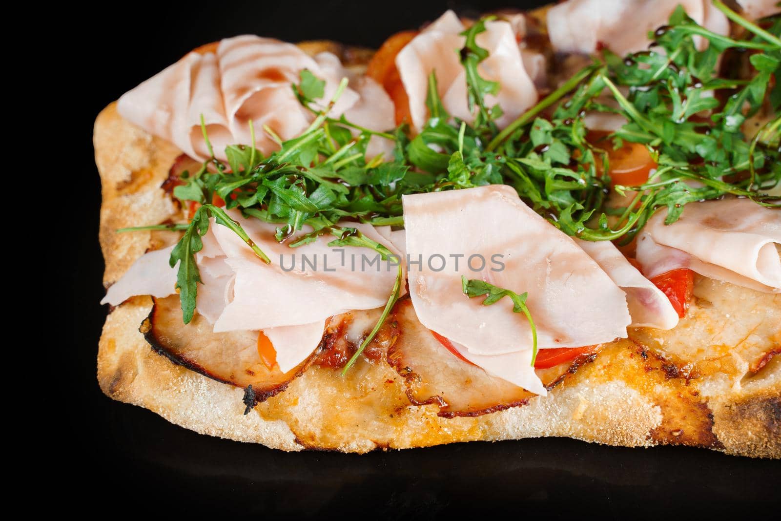 Pinsa romana gourmet italian cuisine. Scrocchiarella traditional dish. Pinsa with meat, arugula, olives, cheese. by Rabizo