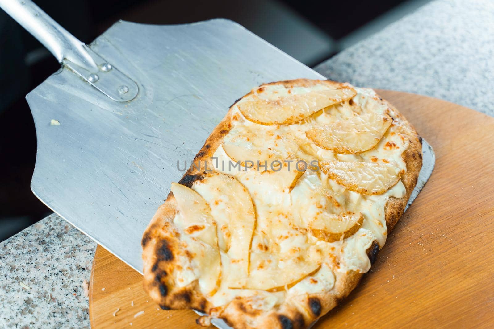 Chef cooking pinsa romana with pear, cheese, prosciutto in delivery box. Scrocchiarella gourmet italian cuisine. by Rabizo
