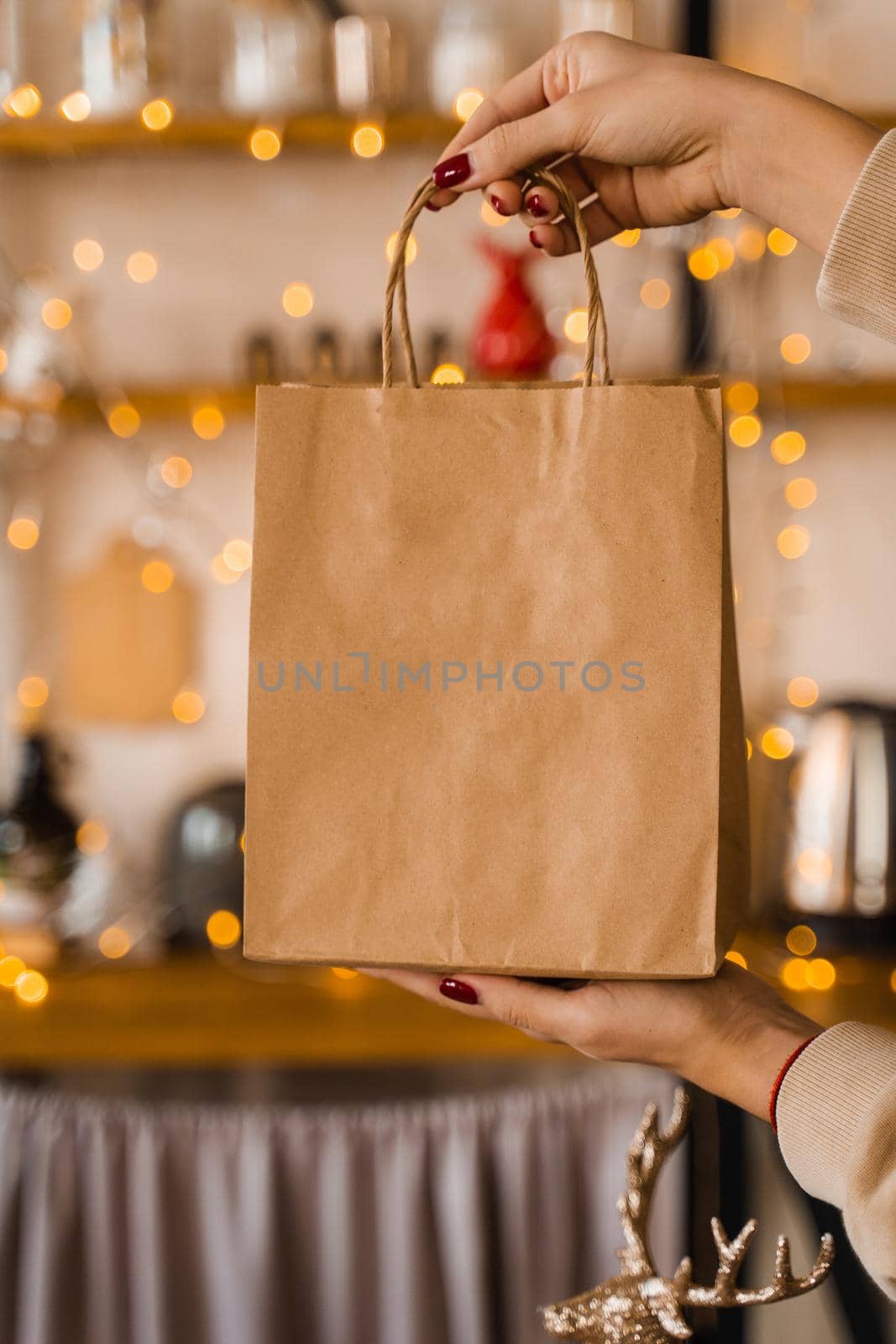 Craft bag for shopping at new year eve. Bag on christmas lights background. New year sale. Vertical photo for social