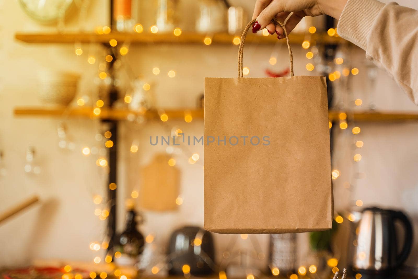 Craft bag for shopping at new year eve. Bag on christmas lights background. New year sale by Rabizo