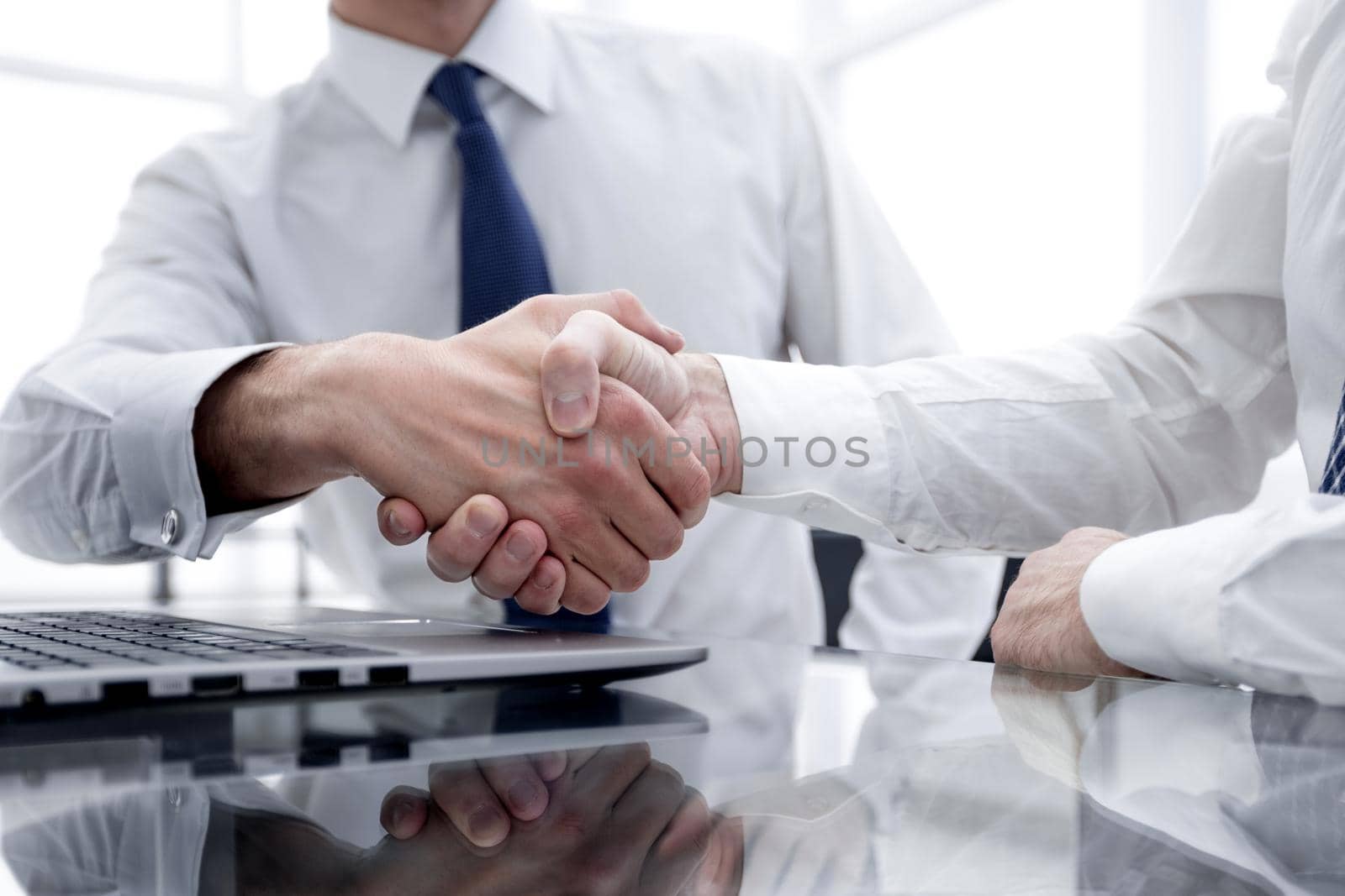 close up.colleagues shaking hands over a Desk .photo with copy space