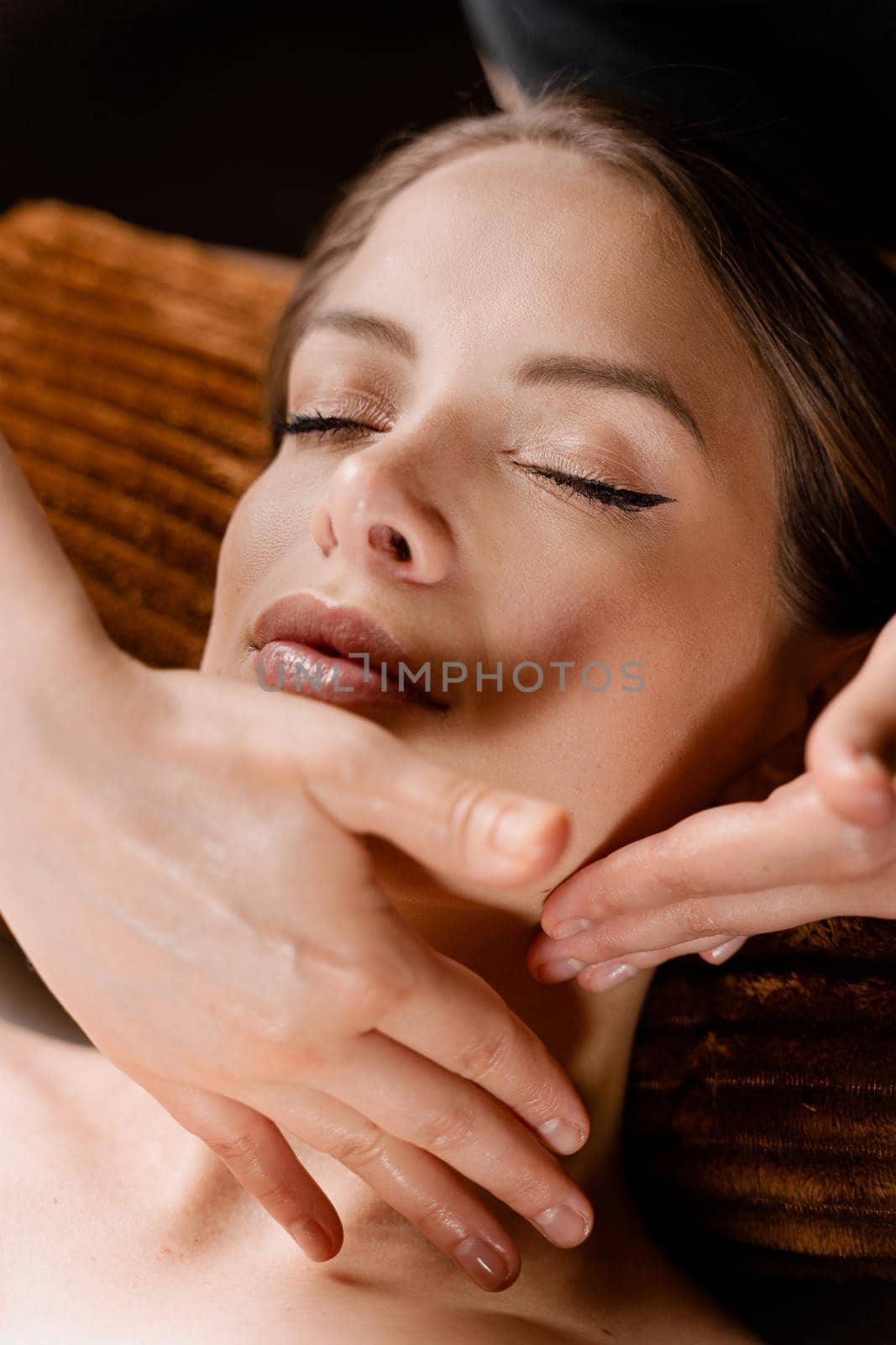 Neck and face massage in the spa. Masseur is making facial beauty treatments for an attractive female model. Relaxation. by Rabizo