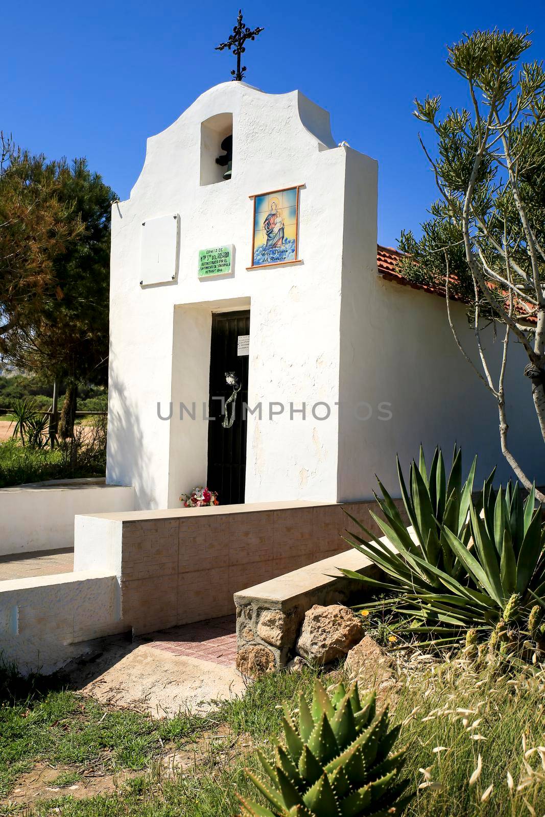 Santa Pola, Alicante, Spain- May 6, 2022: Facade of the Hermitage of Santa Pola Lighthouse seascape under blue sky