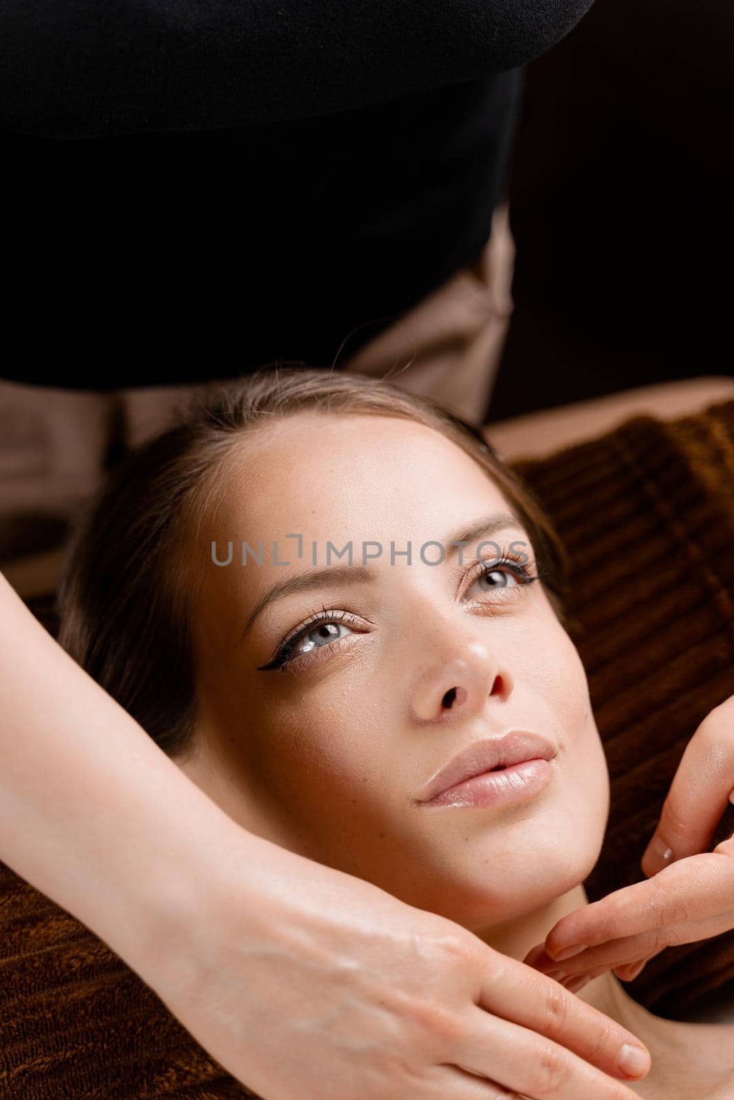 Masseur is making facial massage in spa for model with perfect skin. Beauty procedure