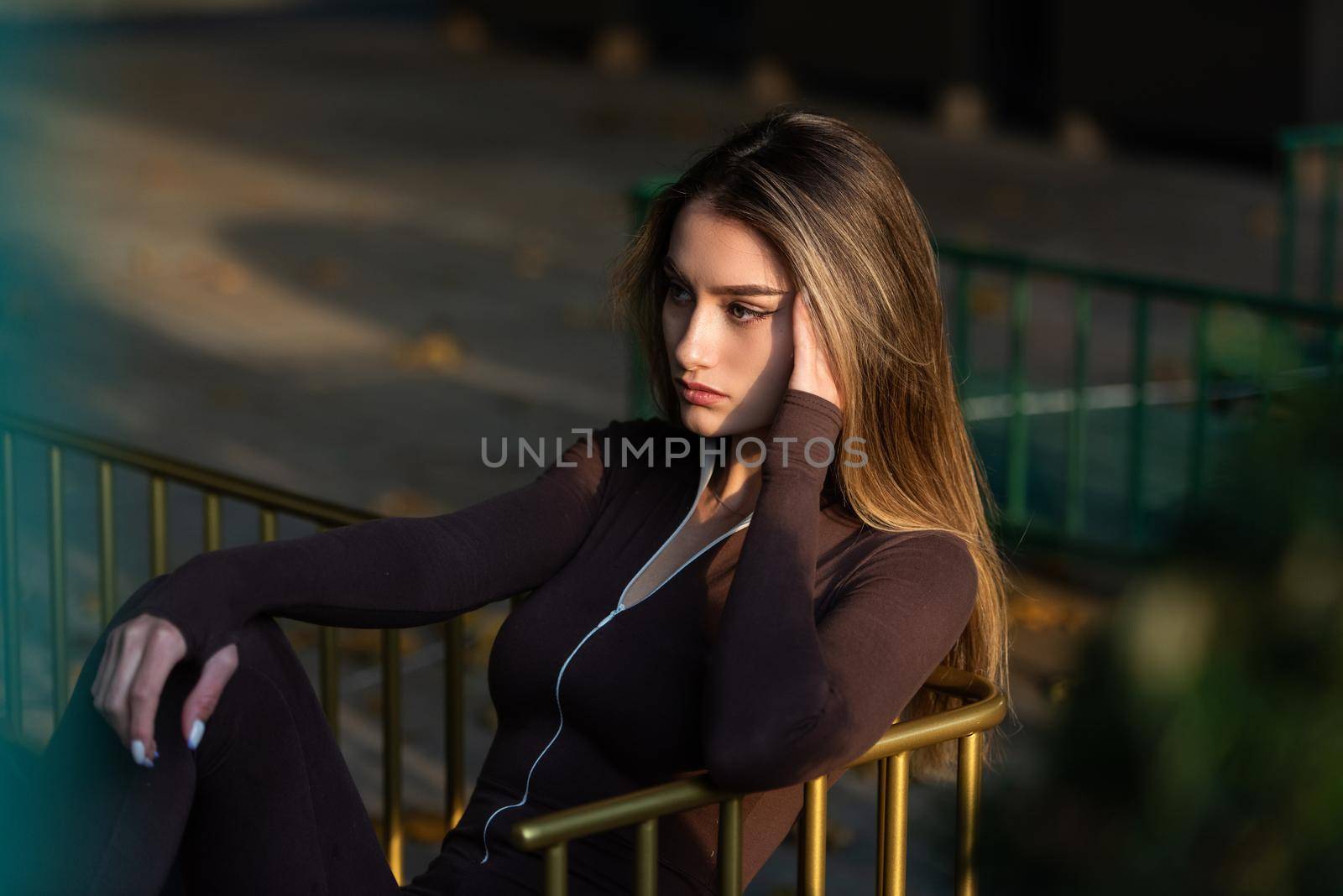 Portrait of a fashionable young brunette woman wearing solid long sleeve bodycon one piece jumpsuits.