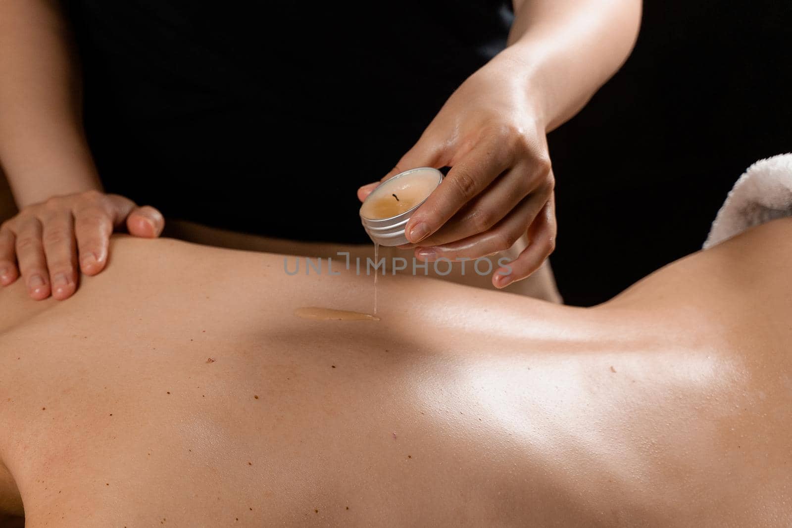 Waxing body massage with candle. Beauty spa procedure. Thai massage with warm wax. by Rabizo