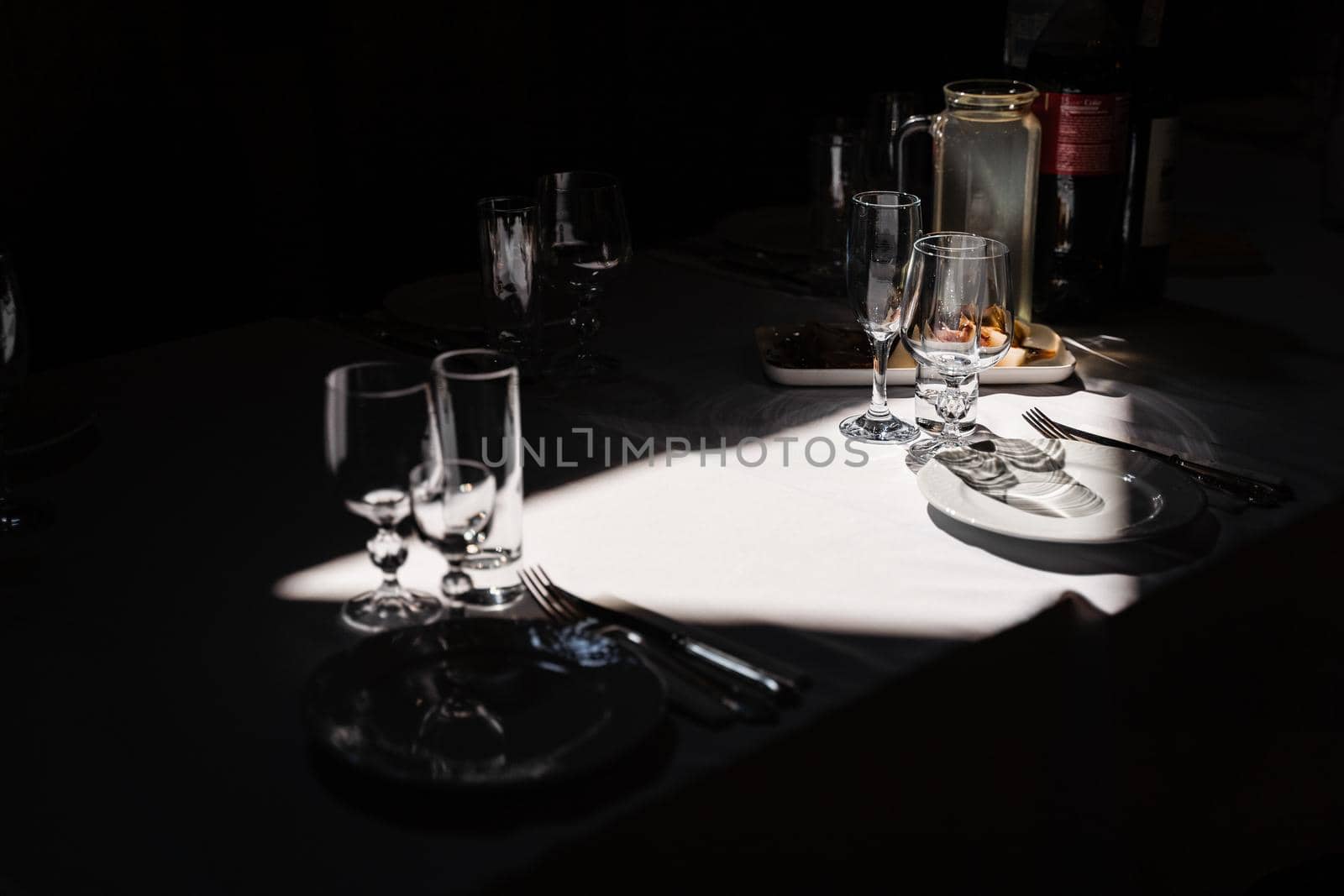 Glasses, plate and cutlery on the table. Table setting in the restaurant. by Rabizo