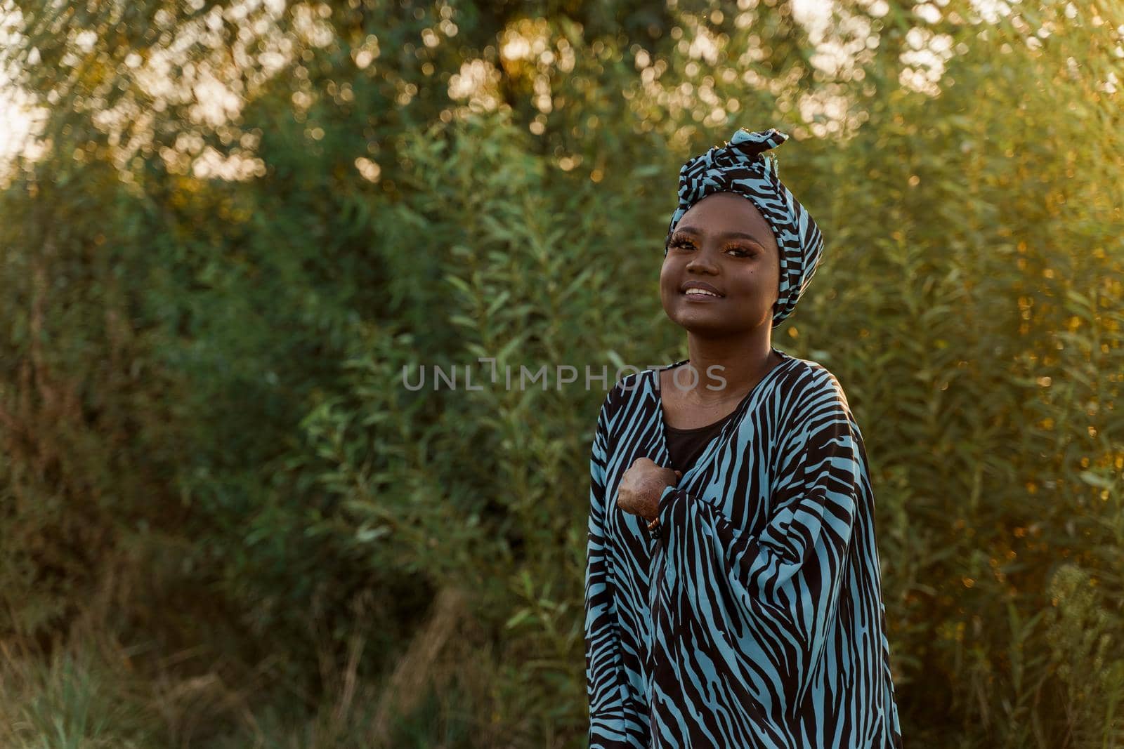 Happy muslim girl in trendy traditional clothes smiles. Woman in traditional blue hijab. Cultures of the all of the world. African people lifestyle