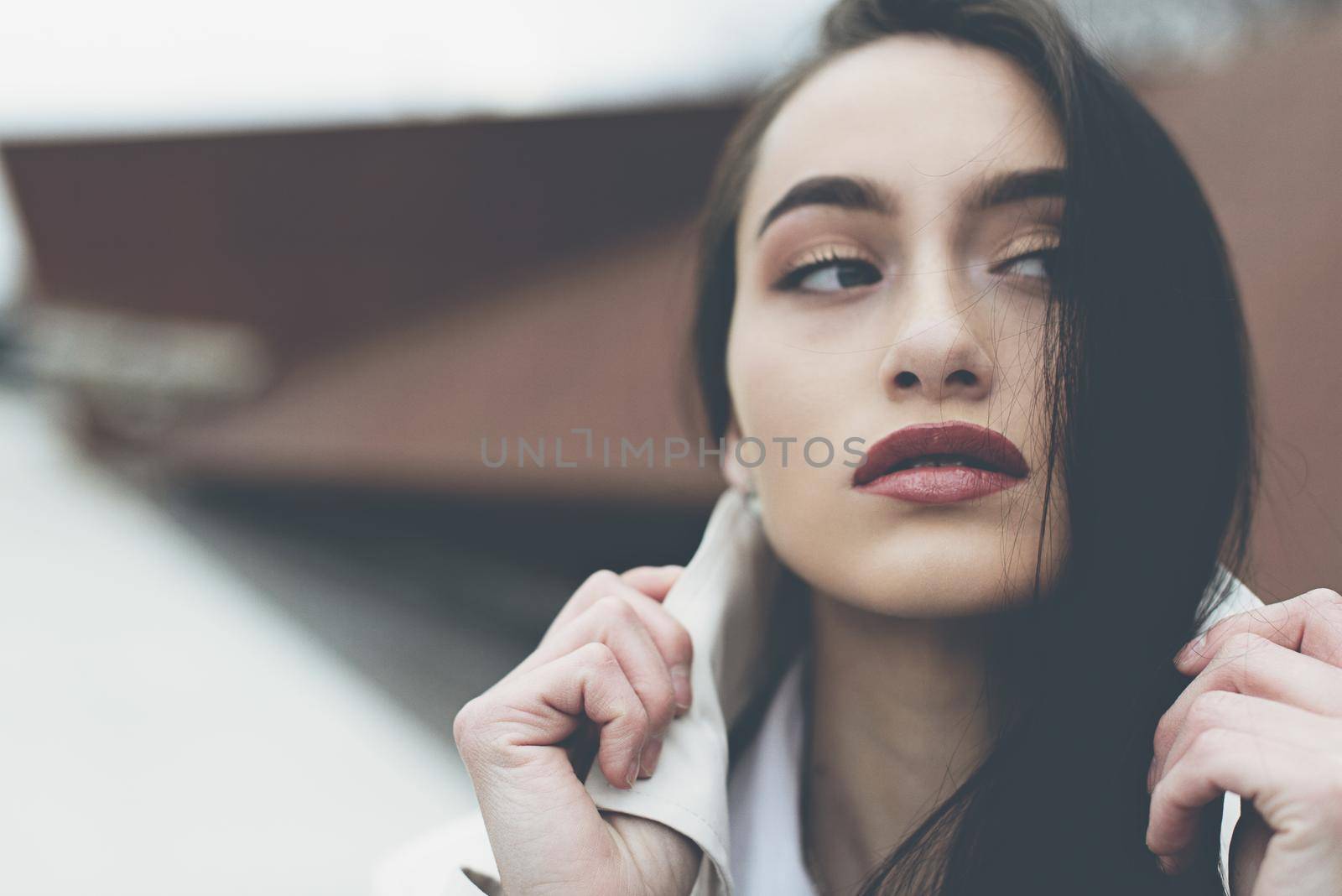 Outdoor portrait of a young beautiful fashionable lady wearing stylish coat . Model looking aside. Female fashion concept. City lifestyle. Close up. by Ashtray25