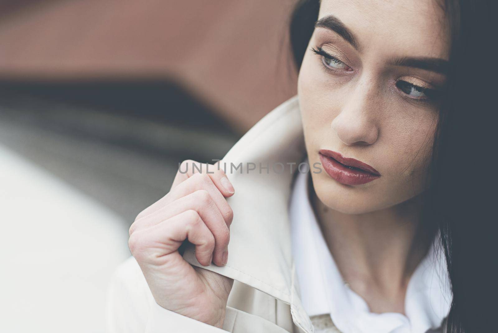 Outdoor portrait of a young beautiful fashionable lady wearing stylish coat . Model looking aside. Female fashion concept. City lifestyle. Close up. by Ashtray25