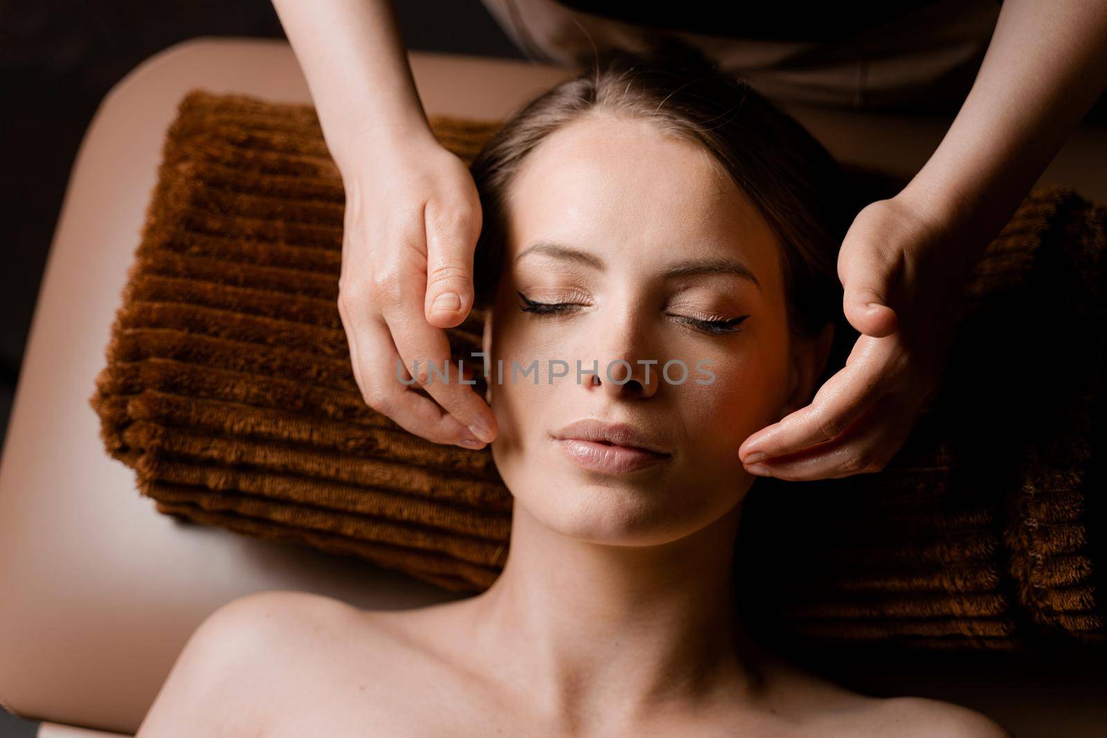 Neck and face massage in the spa. Masseur is making facial beauty treatments for an attractive female model. Relaxation. by Rabizo