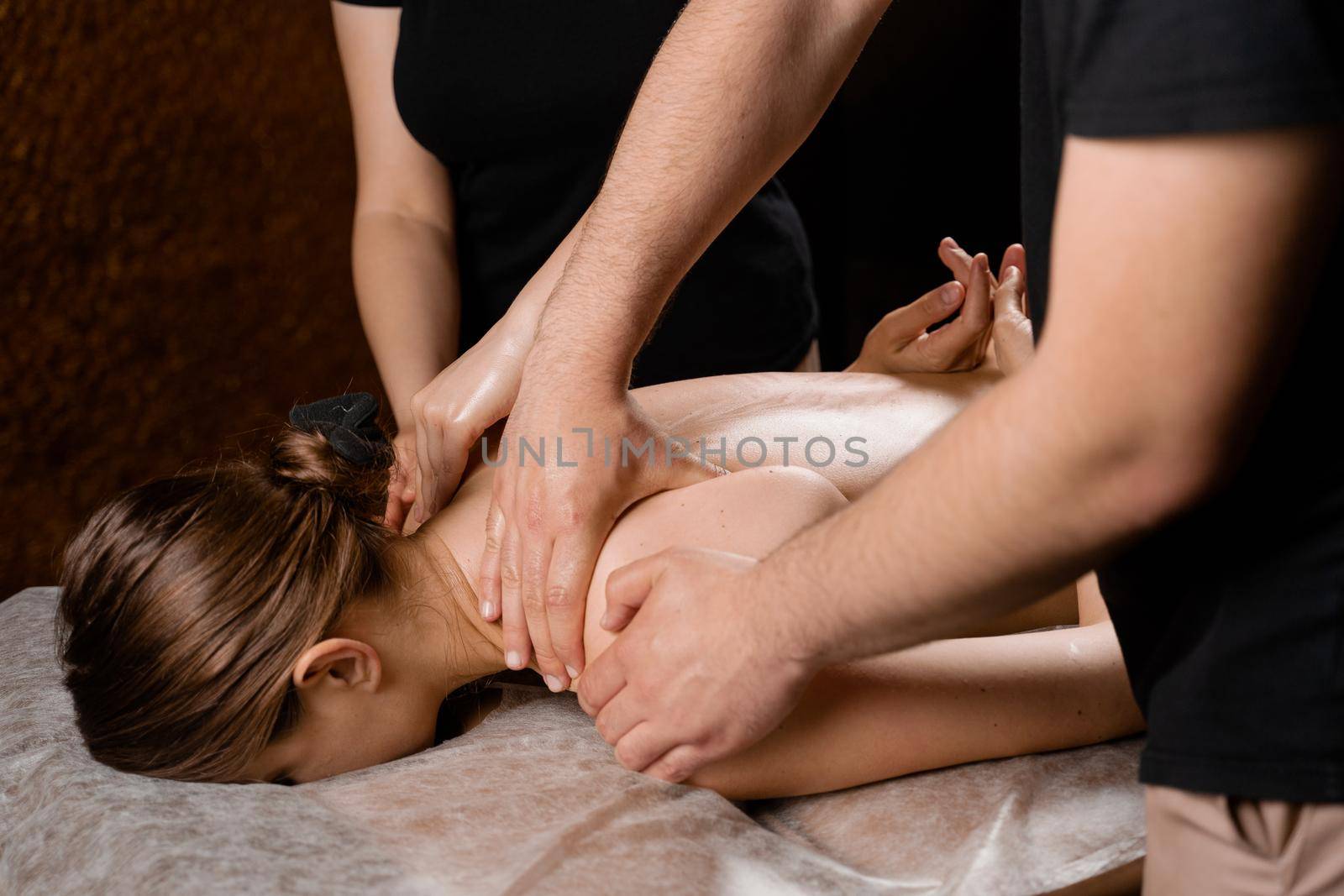 4 hands massage in spa. Two masseurs are making four hands relaxing massage with oil for girl. Relaxation. Manual therapy by Rabizo