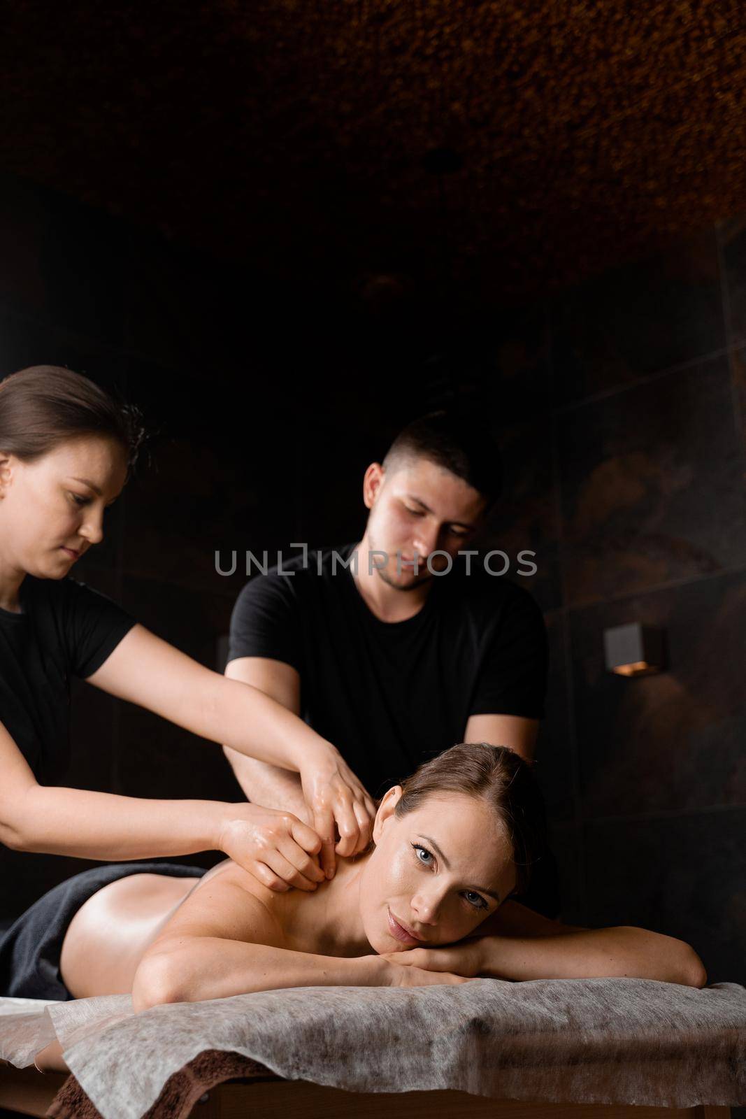 4 hands massage in spa. Two masseurs are making four hands relaxing massage with oil for girl. Relaxation. Manual therapy.