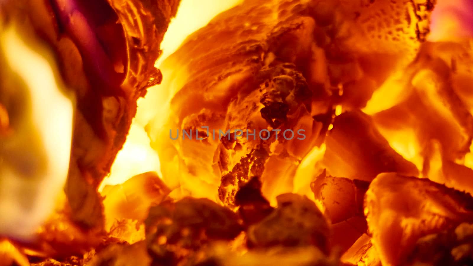 Close up shot of burning firewood in the fireplace. low light by lempro