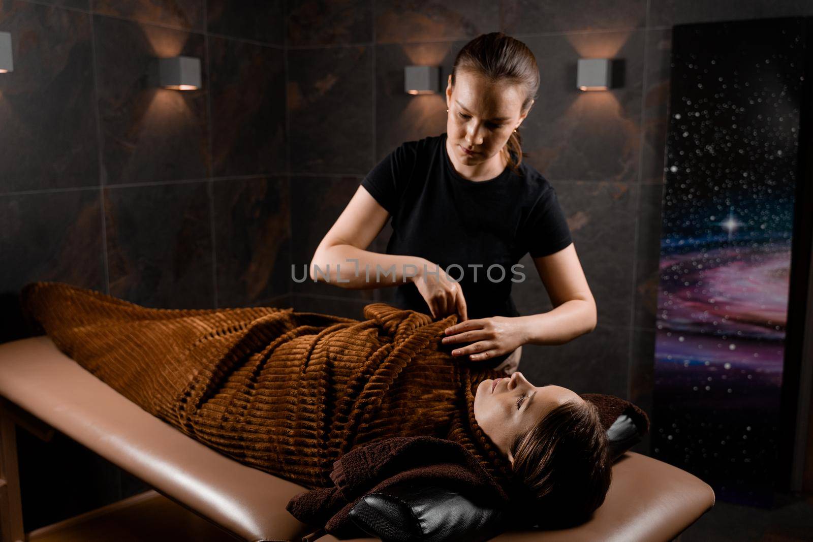 Full body wrap in warm blanket after chocolate massage beauty treatment for female model in spa. by Rabizo