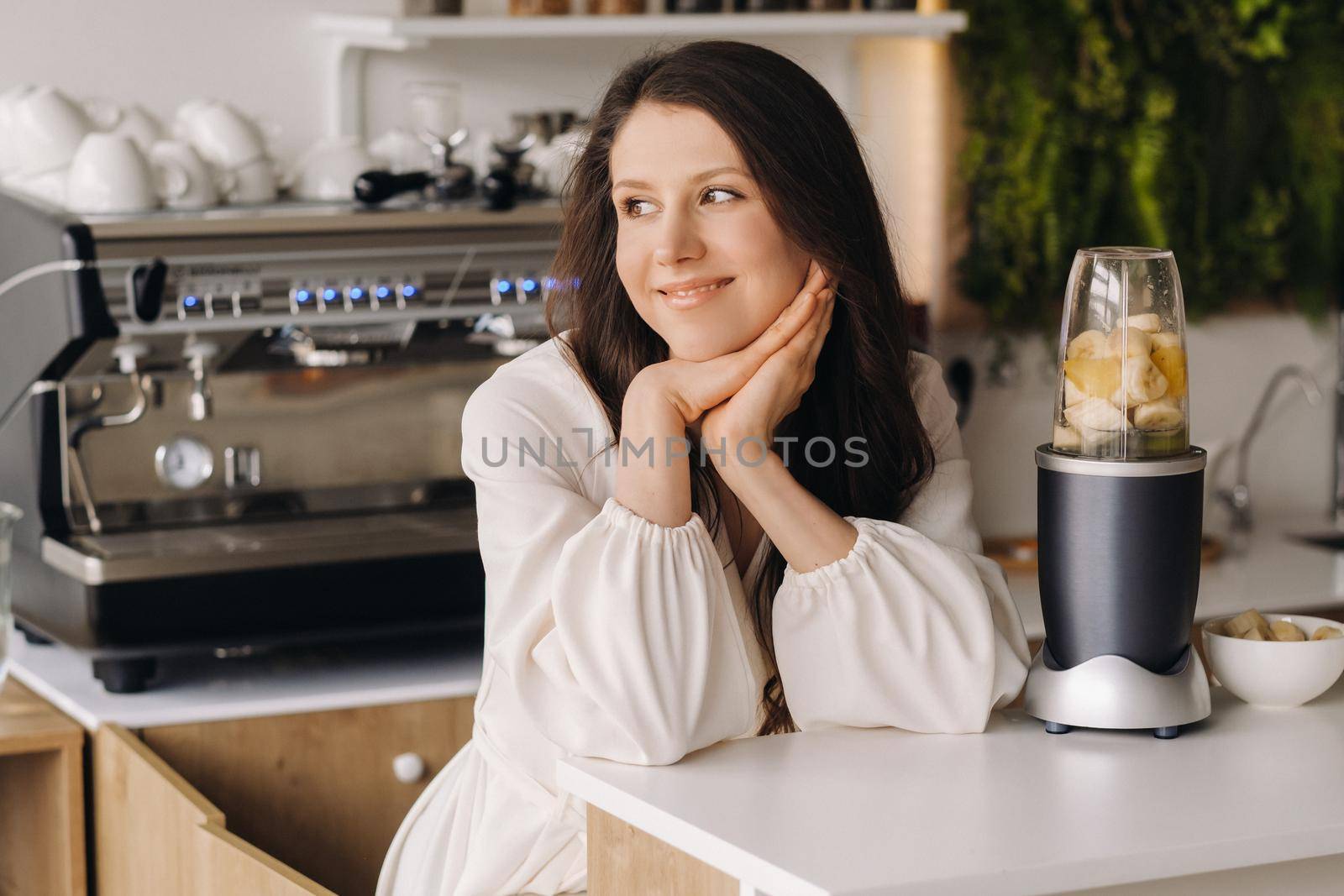 Portrait of a girl who makes a delicious fruit cocktail in the kitchen. Diet for weight loss.