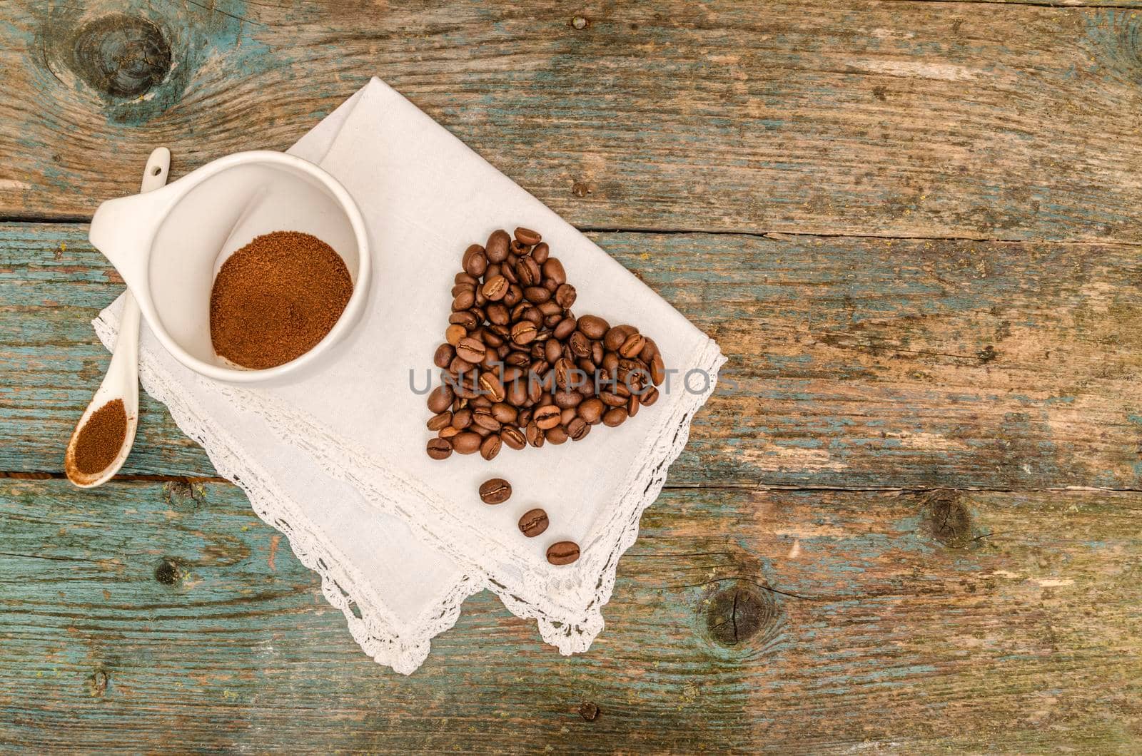 Heart made from coffee beans and cup of coffee on wooden background by zimages