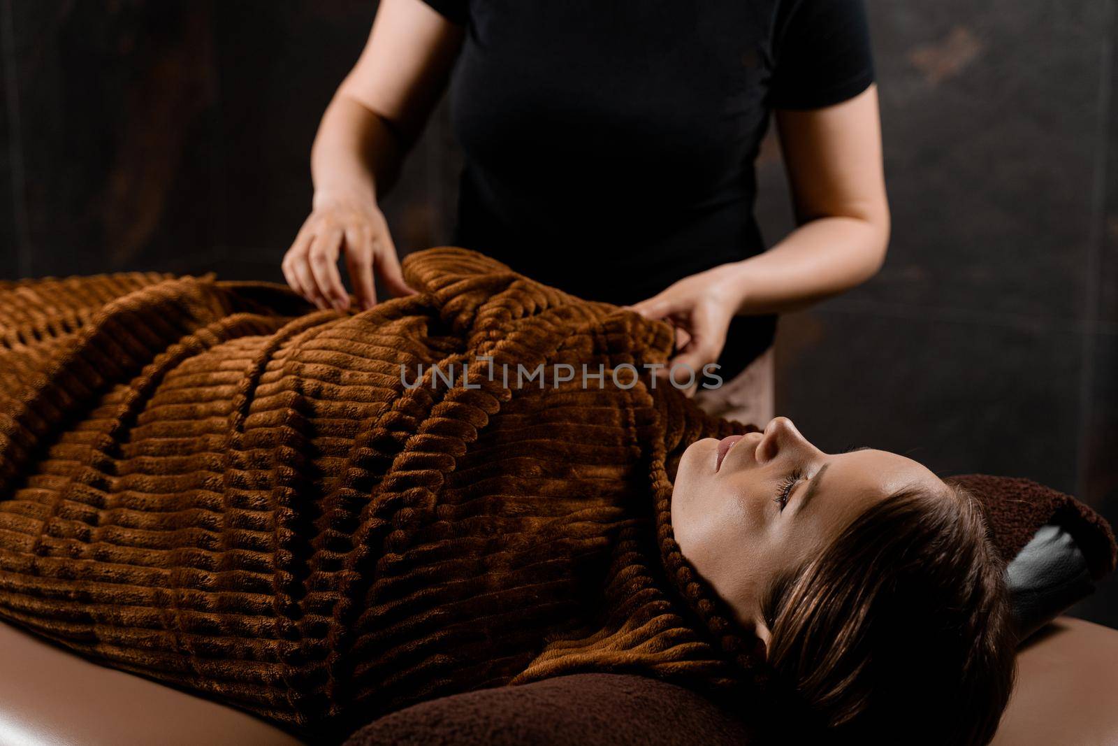 Full body wrap in warm blanket after chocolate massage beauty treatment for female model in spa. by Rabizo