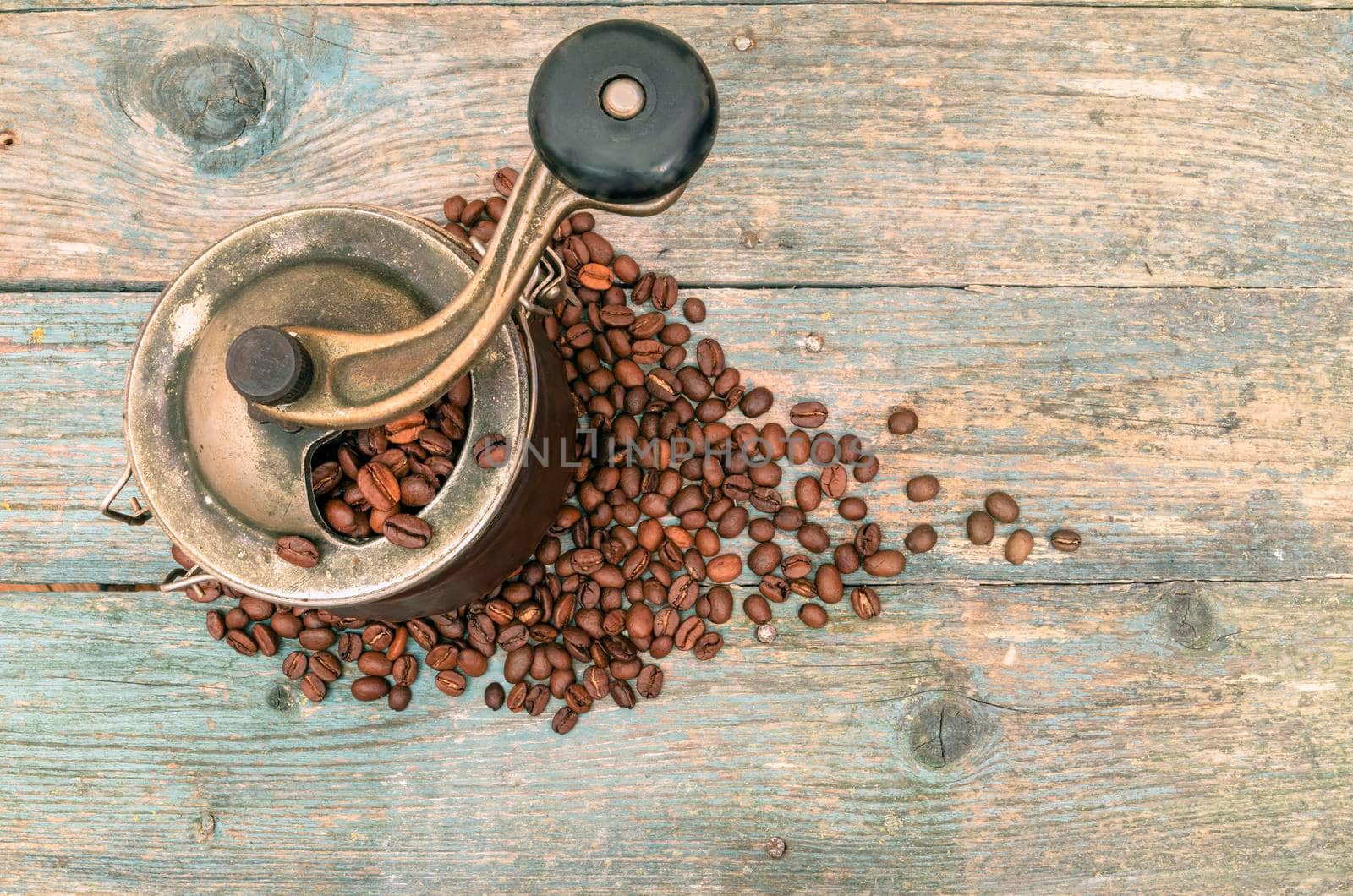 Coffee beans and grinders on old wooden table by zimages