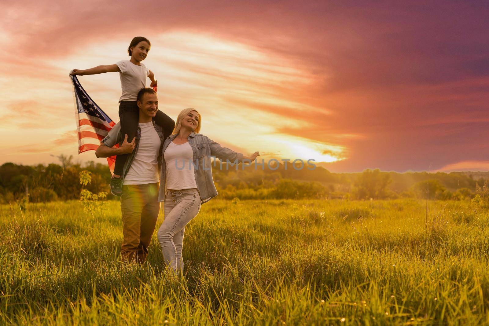 Happy family in wheat field with USA american flag on back. by Andelov13