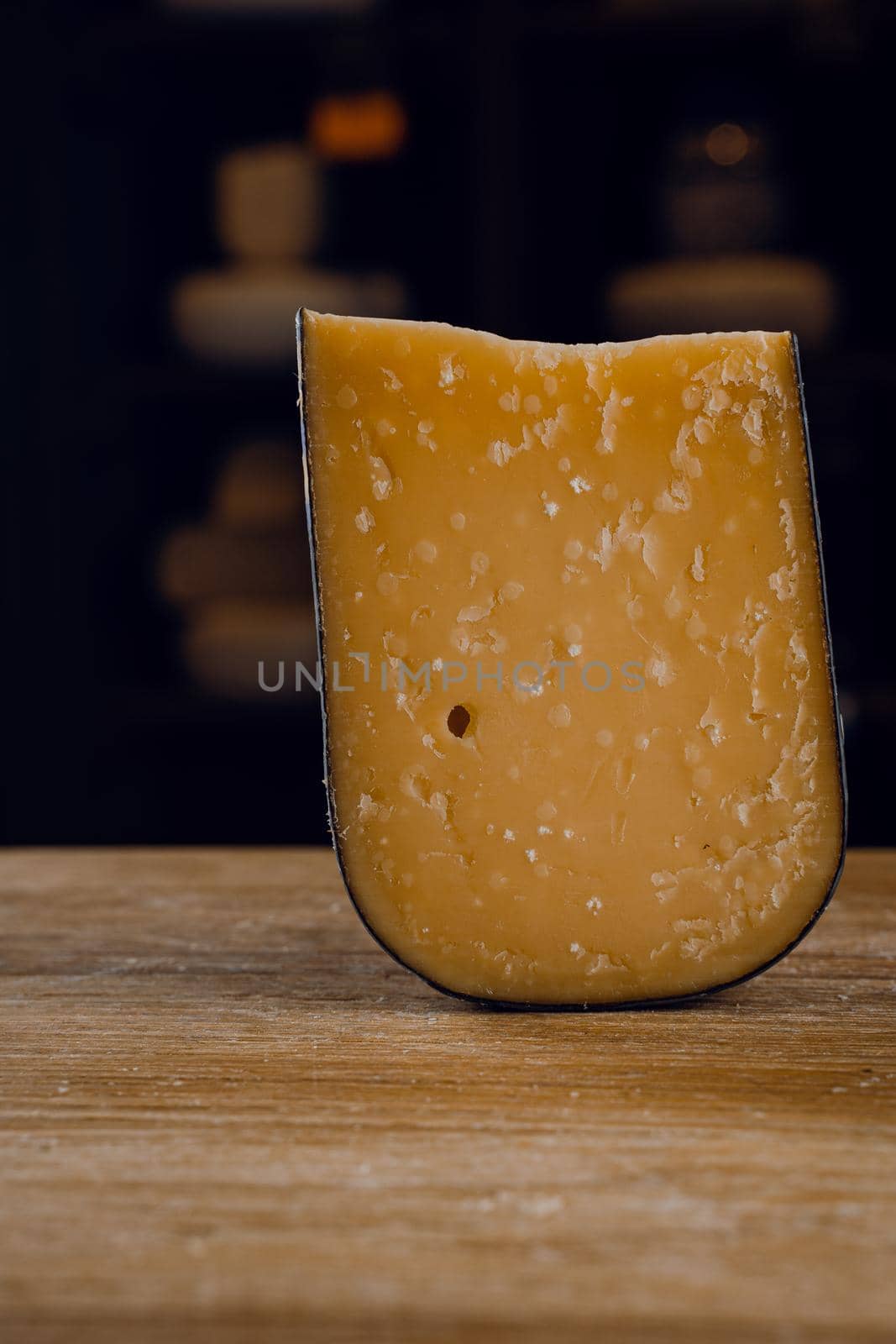 Parmesan hard aged cheese on wooden background. Snack tasty piece of cheese for appetizer. by Rabizo