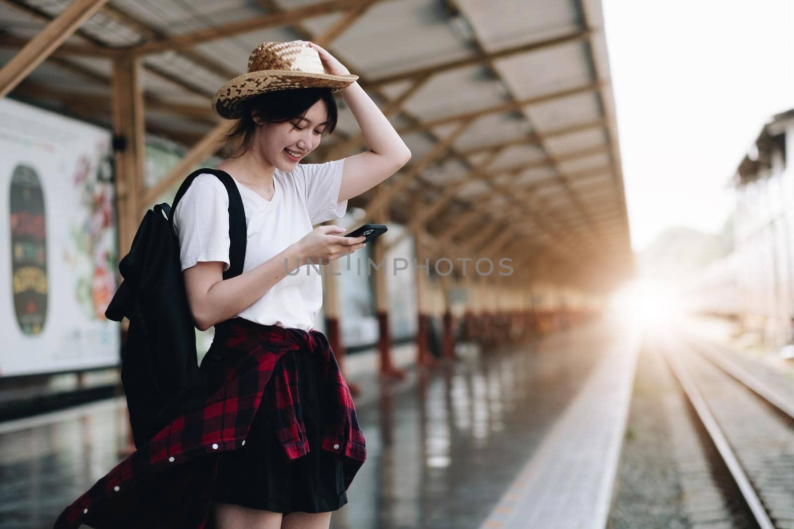 Young traveler woman looking for friend planning trip at train station. Summer and travel lifestyle concept.