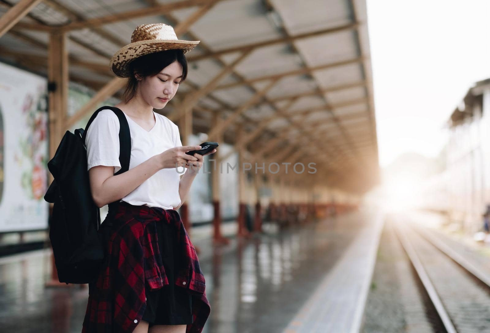 Young traveler woman looking for friend planning trip at train station. Summer and travel lifestyle concept.