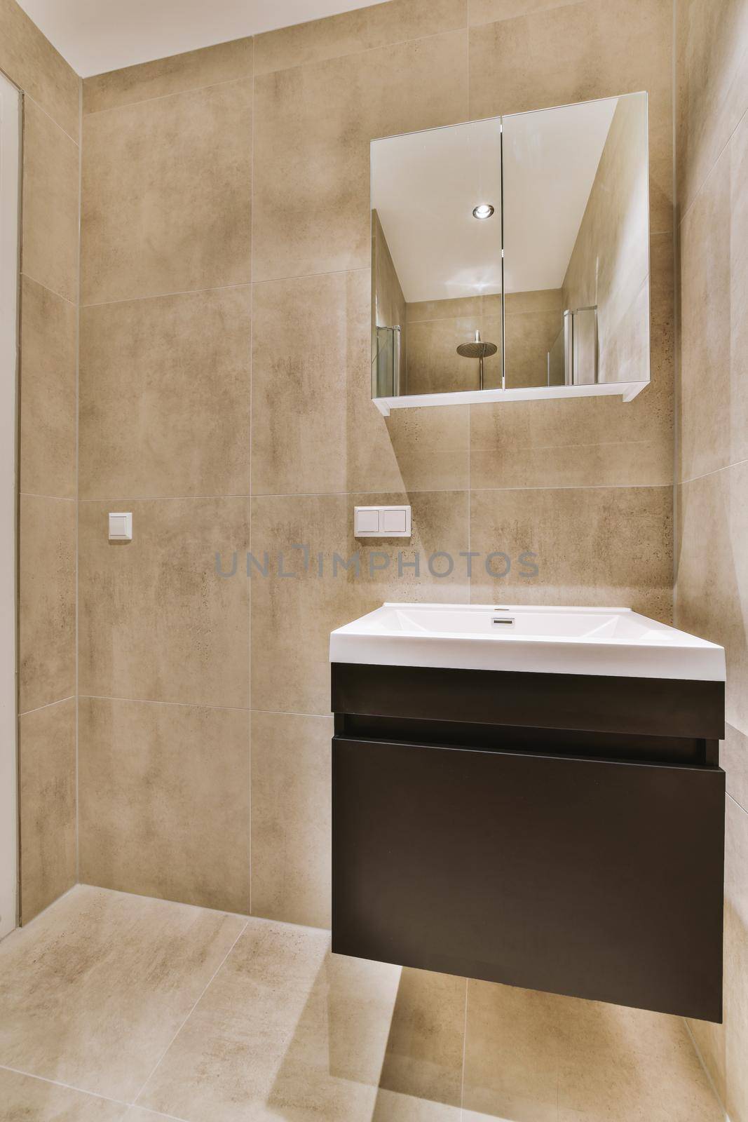 Sink and mirror in modern bathroom with beige marble walls