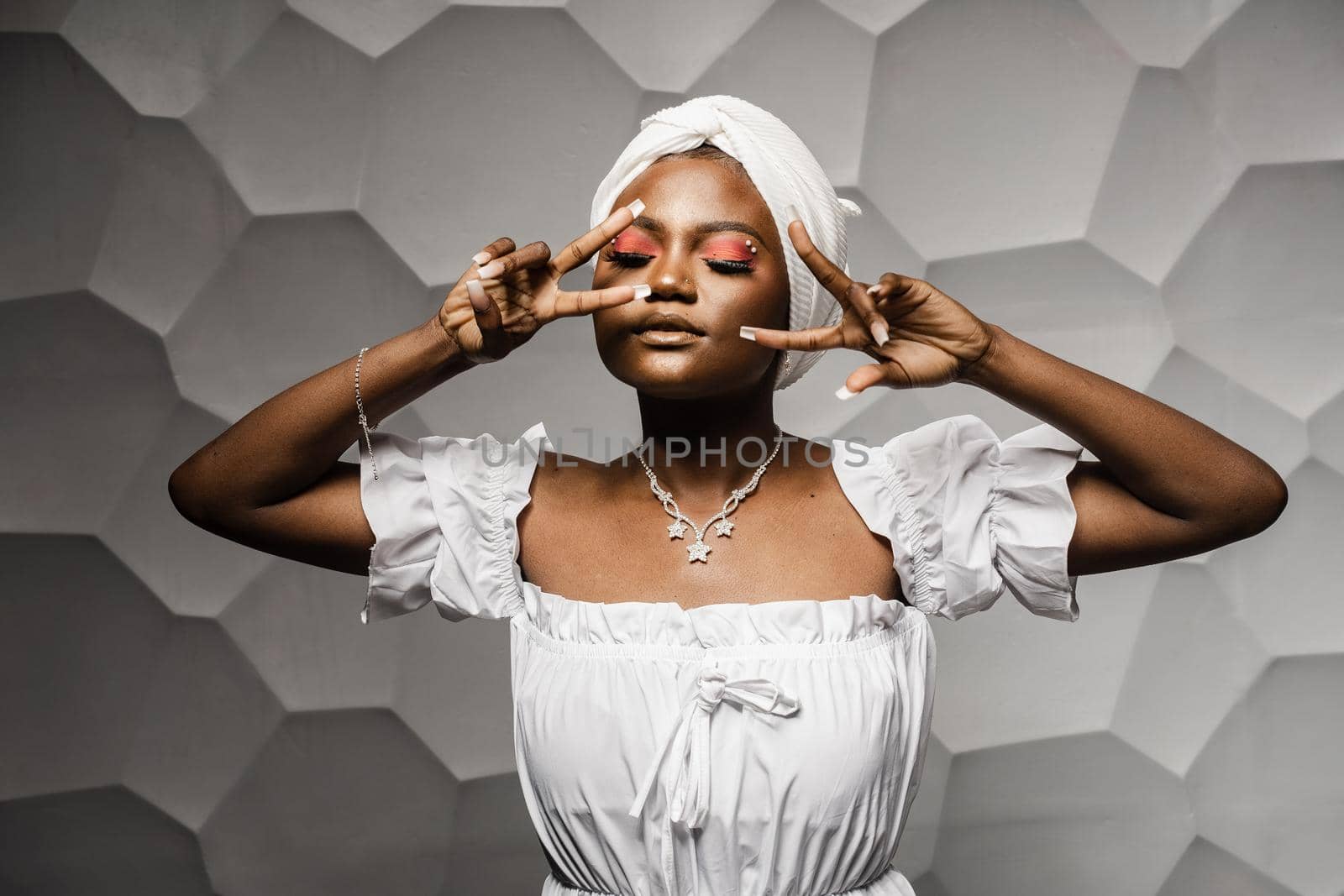 Black muslim woman holding up 2 fingers have party. African girl is celebrating her birthday and having fun.