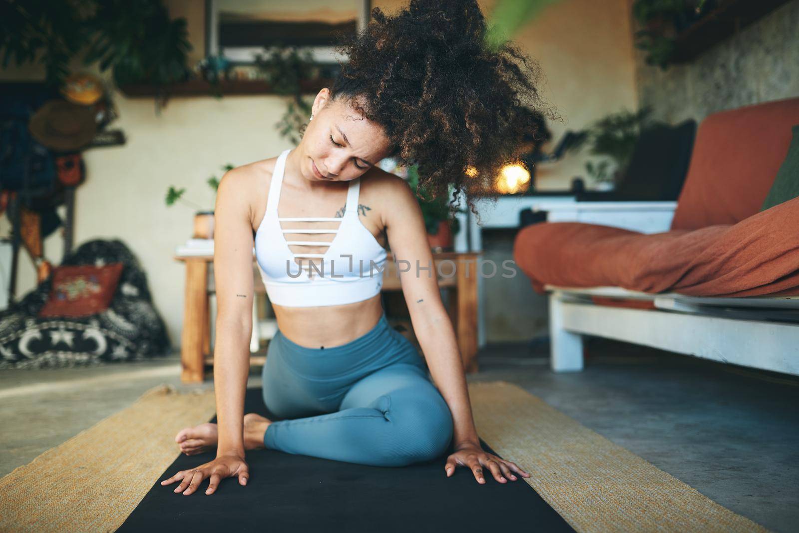 Shot of a woman doing yoga in her living room