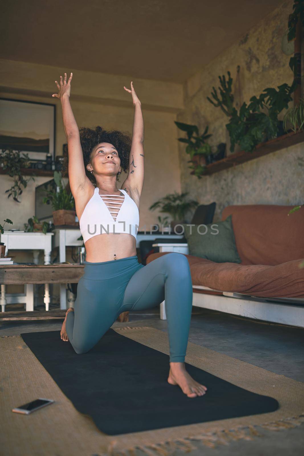 Shot of a young woman practicing yoga in her living room