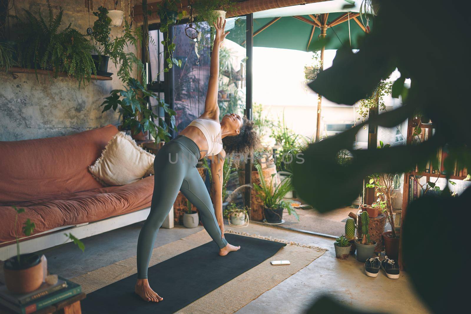 Shot of a young woman doing yoga in her living room